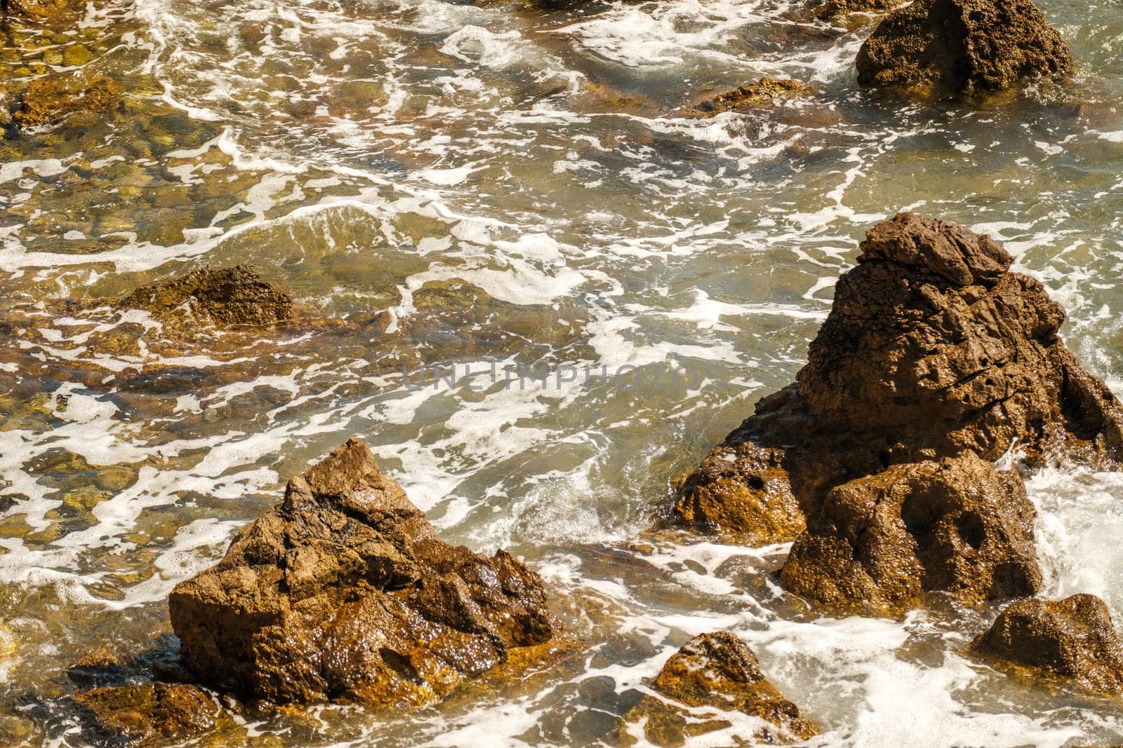 Ocean waves crashing on rocks on coastline at high tide by vladimka