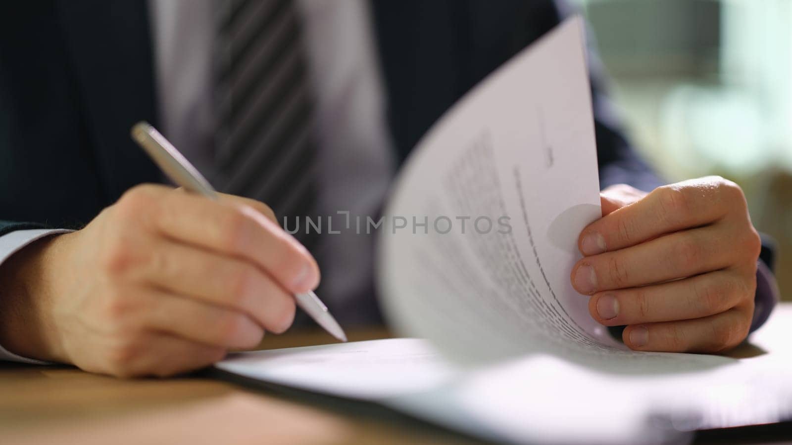 Businessman in suit signing document at work in office closeup. Earning strategies in business financial deals concept