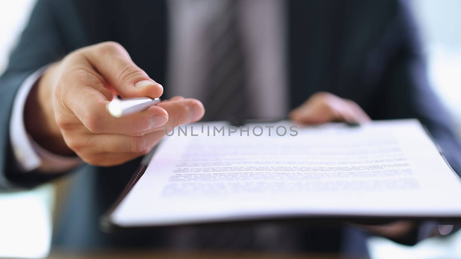 Businessman giving client ballpoint pen and clipboard with contract to sign closeup. Certification of important papers concept