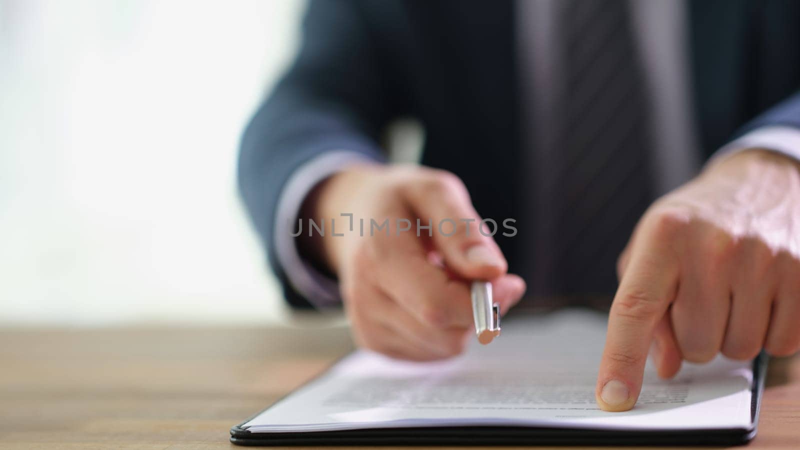 Businessman giving client ballpoint pen and showing with finger where to signing in document closeup. Working with partners in business concept