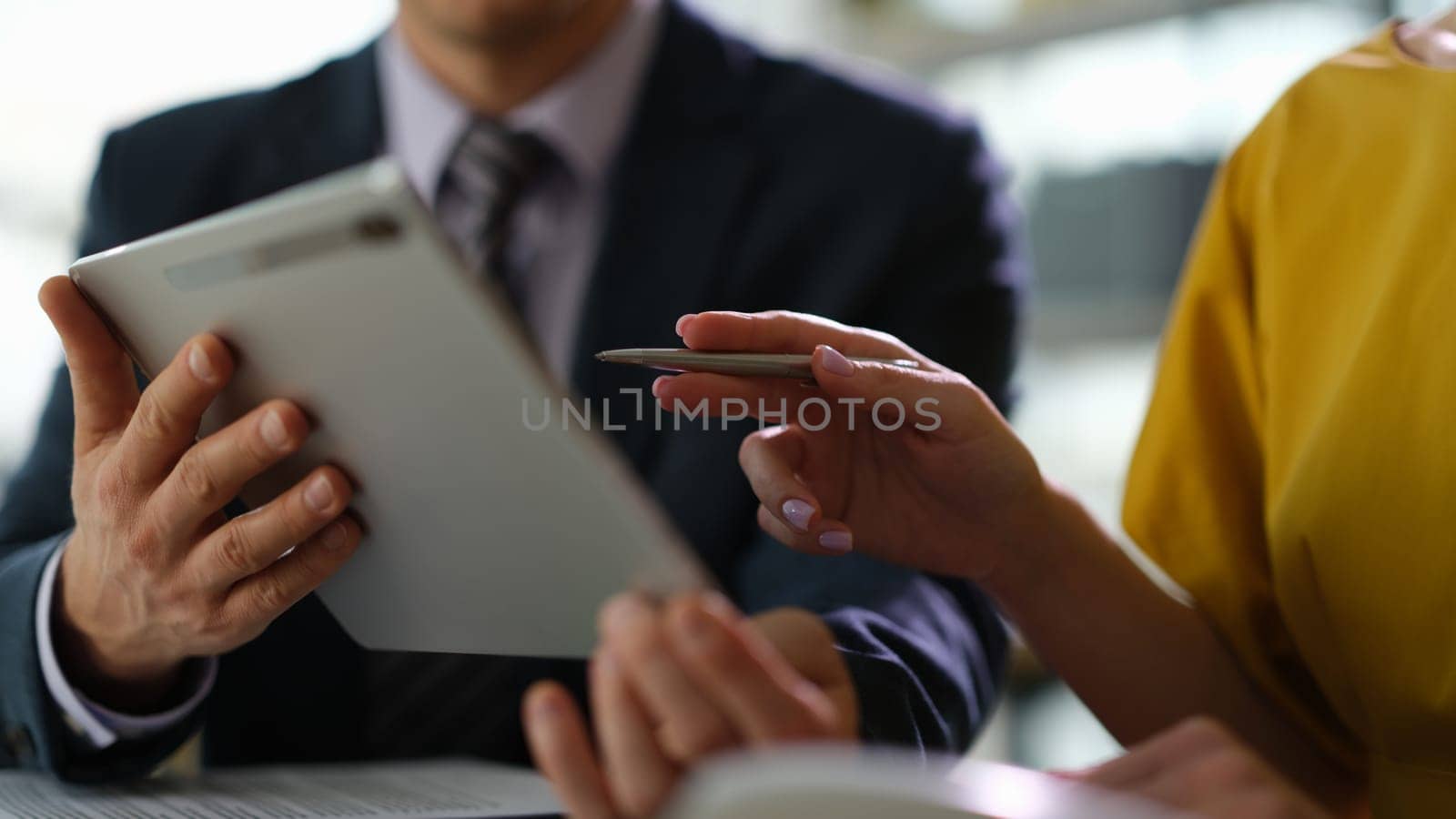 Business colleagues studying information on digital tablet in office closeup. Remote work with clients and partners concept