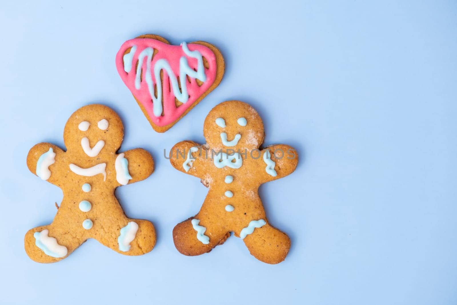 Black and white homosexual couple, two gingerbread girls and heart on the blue background with copy space for St Valentines Day by vladimka