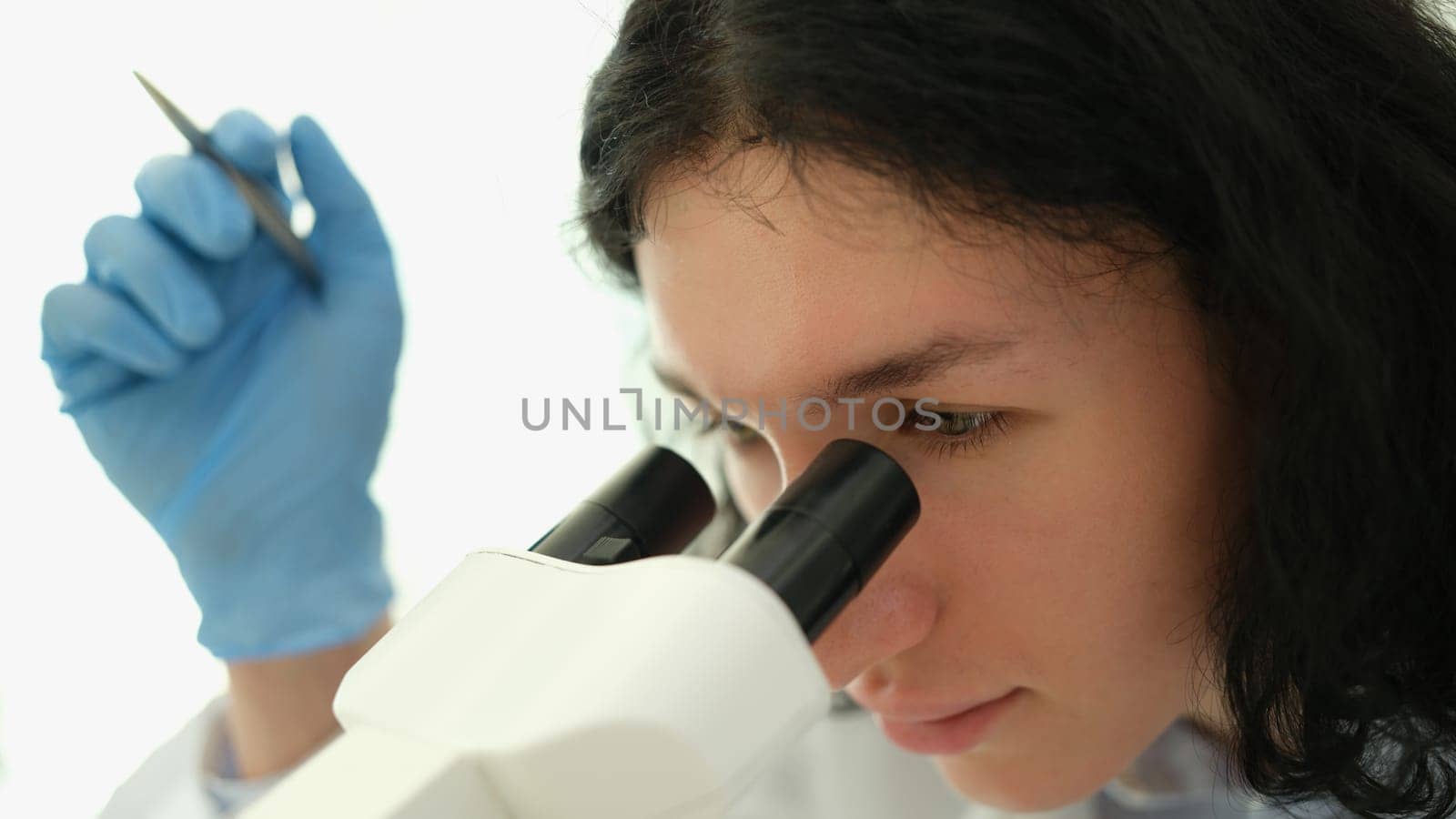 Scientist chemist looking into microscope in chemical laboratory. Medical lab blood tests concept