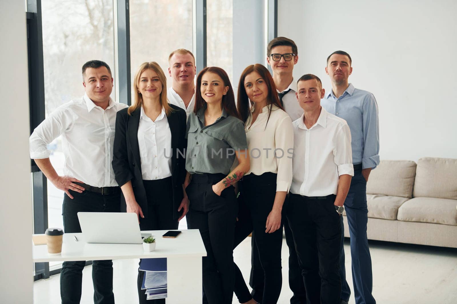 Standing together. Group of people in official formal clothes that is indoors in the office.