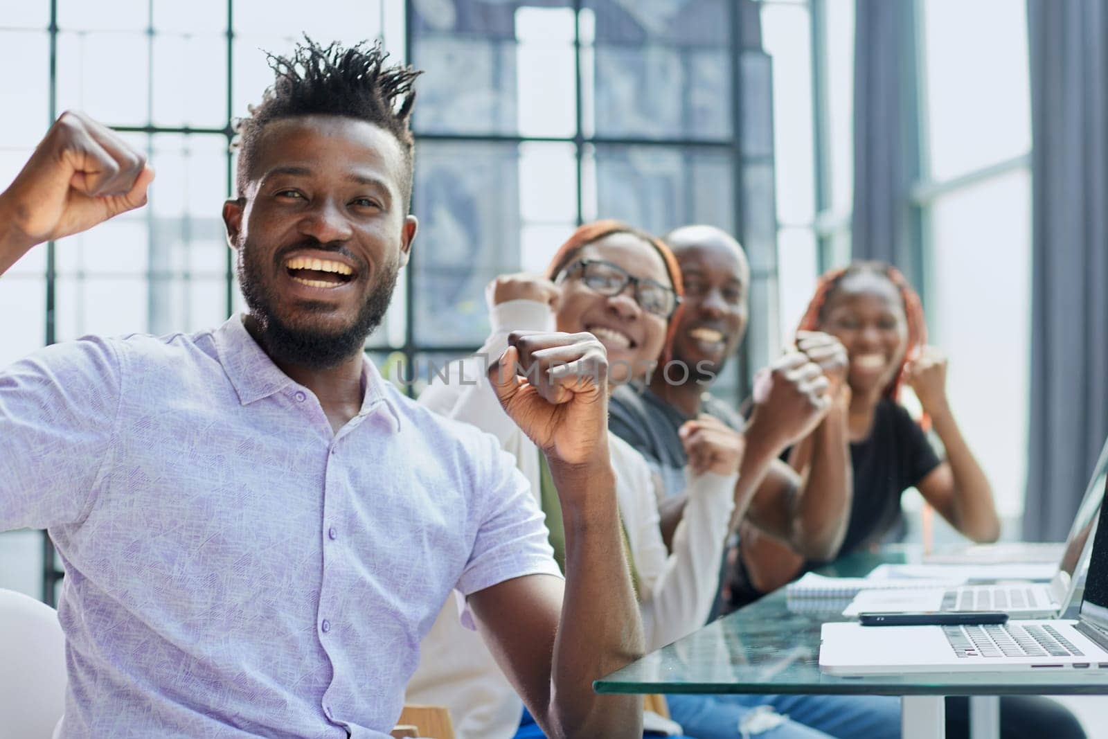 Happy young African-American man and his team in background