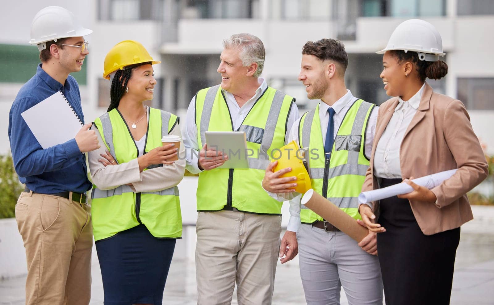 Construction site, team and meeting at a building for planning, creative and collaboration. Architecture, business people and designer group with blueprint, documents and engineering development plan.