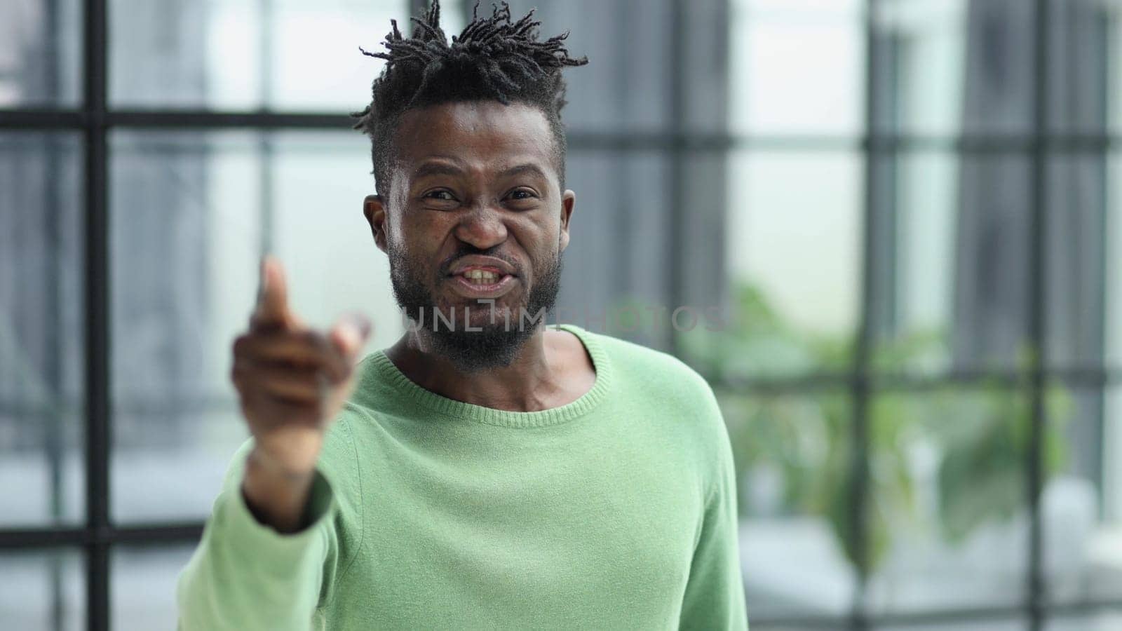 Handsome businessman pointing his finger to the camera and slicking virtual image or text. Young african american guy