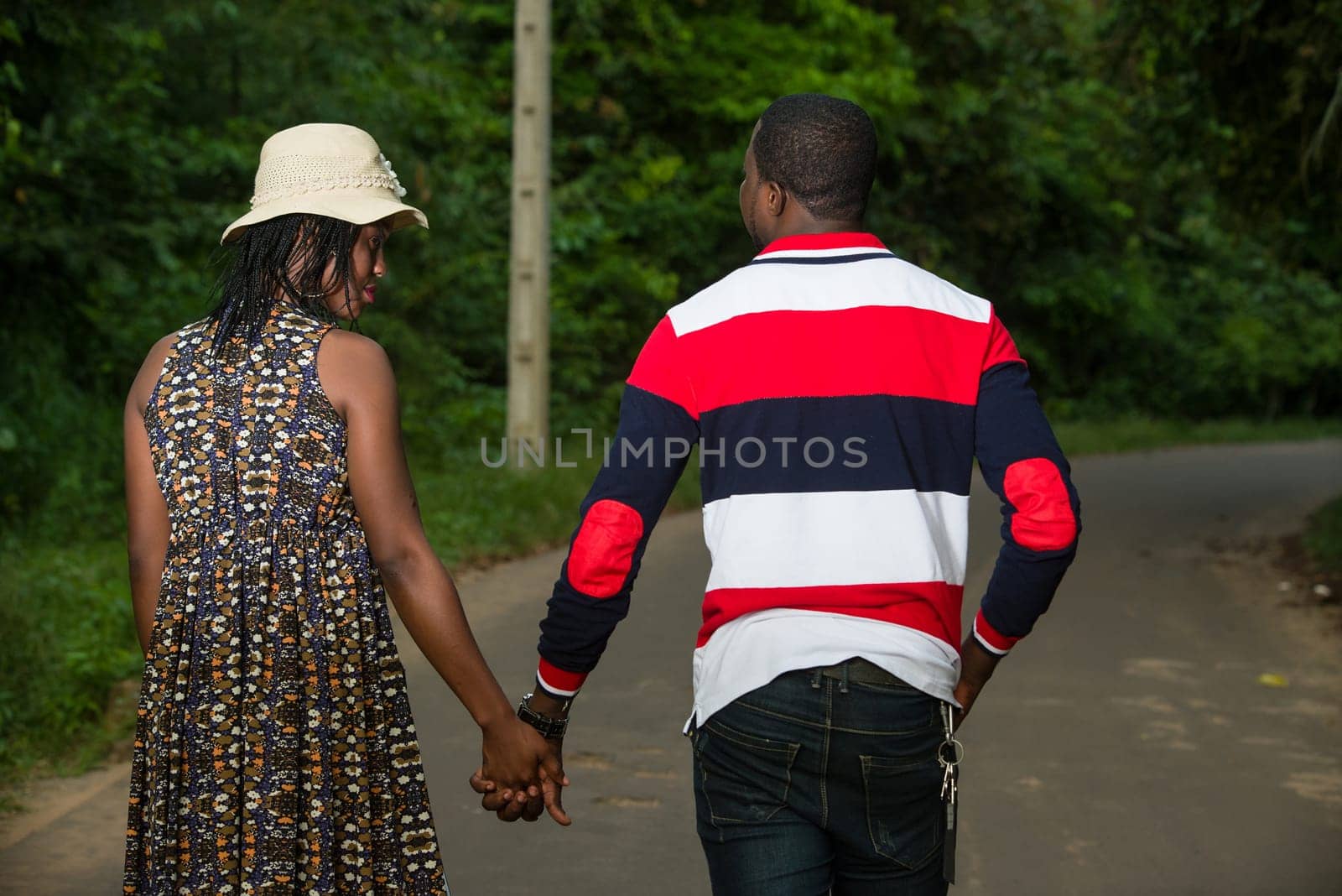 Young man strolling in the countryside with his girlfriend holding hands.