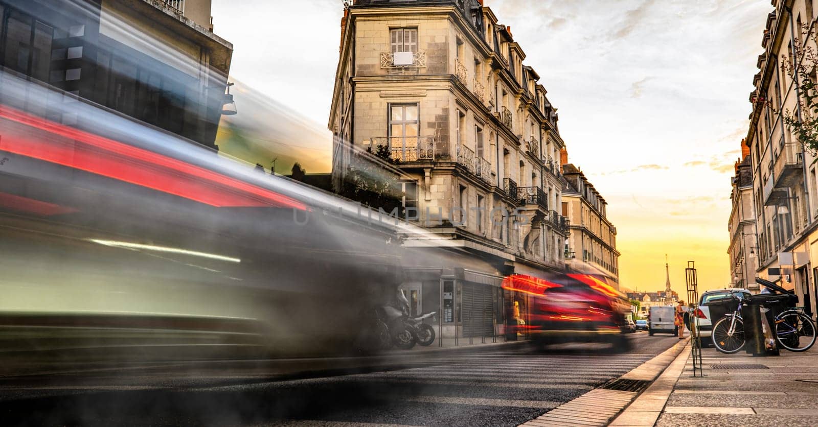 European street with car trails in the evening. Beautiful evening lights in city with long exposure,