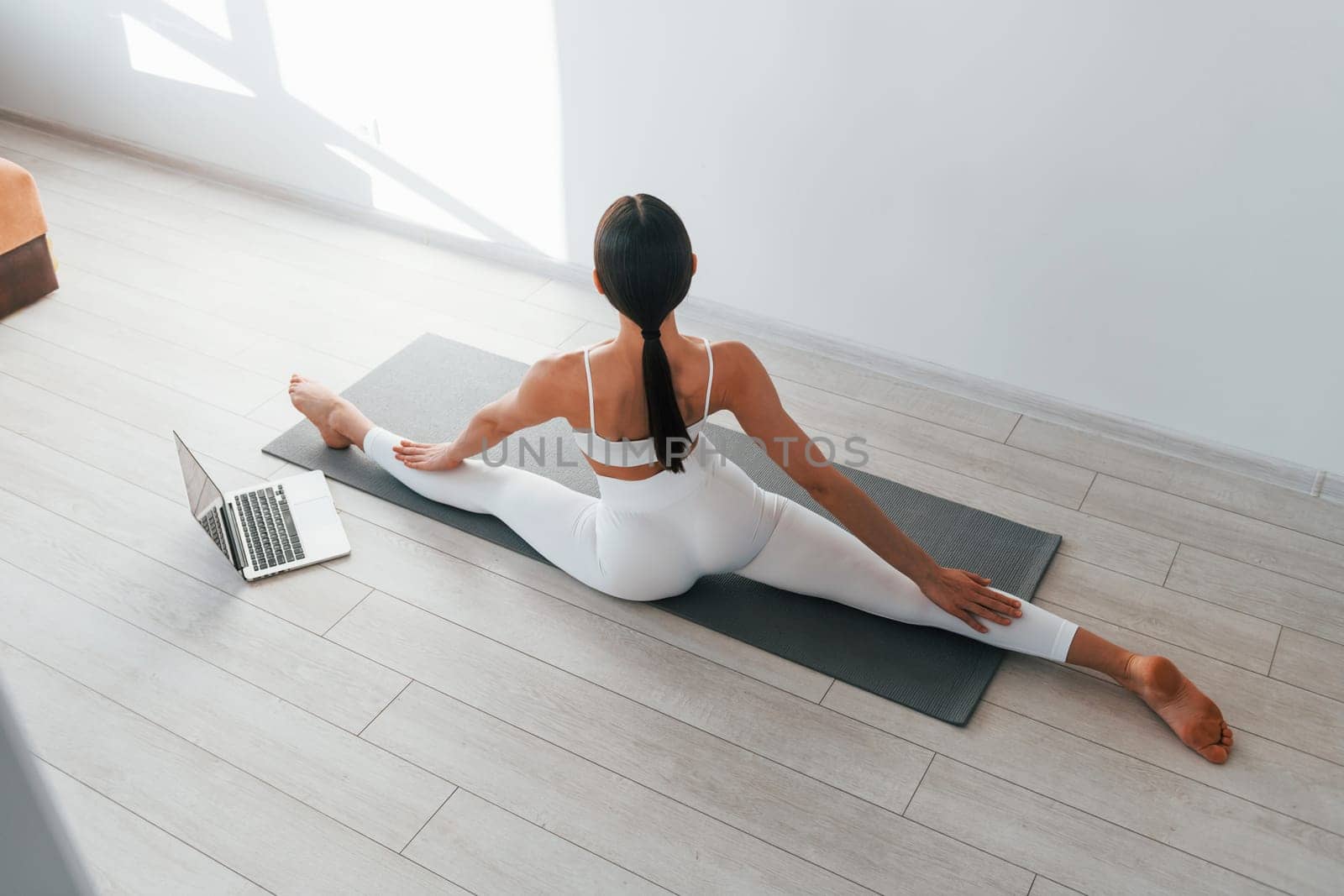 With laptop. Young caucasian woman with slim body shape is indoors at daytime.