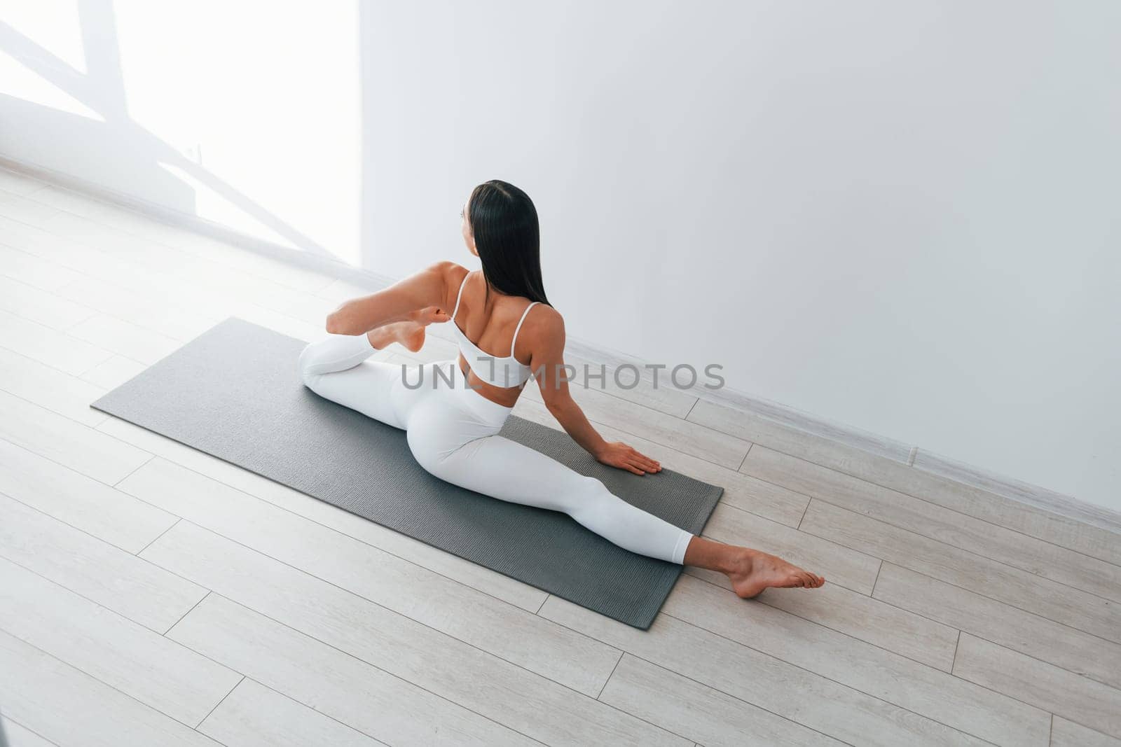Young caucasian woman with slim body shape is indoors at daytime by Standret