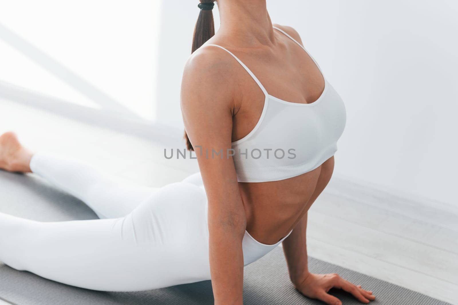 Young caucasian woman with slim body shape is indoors at daytime.