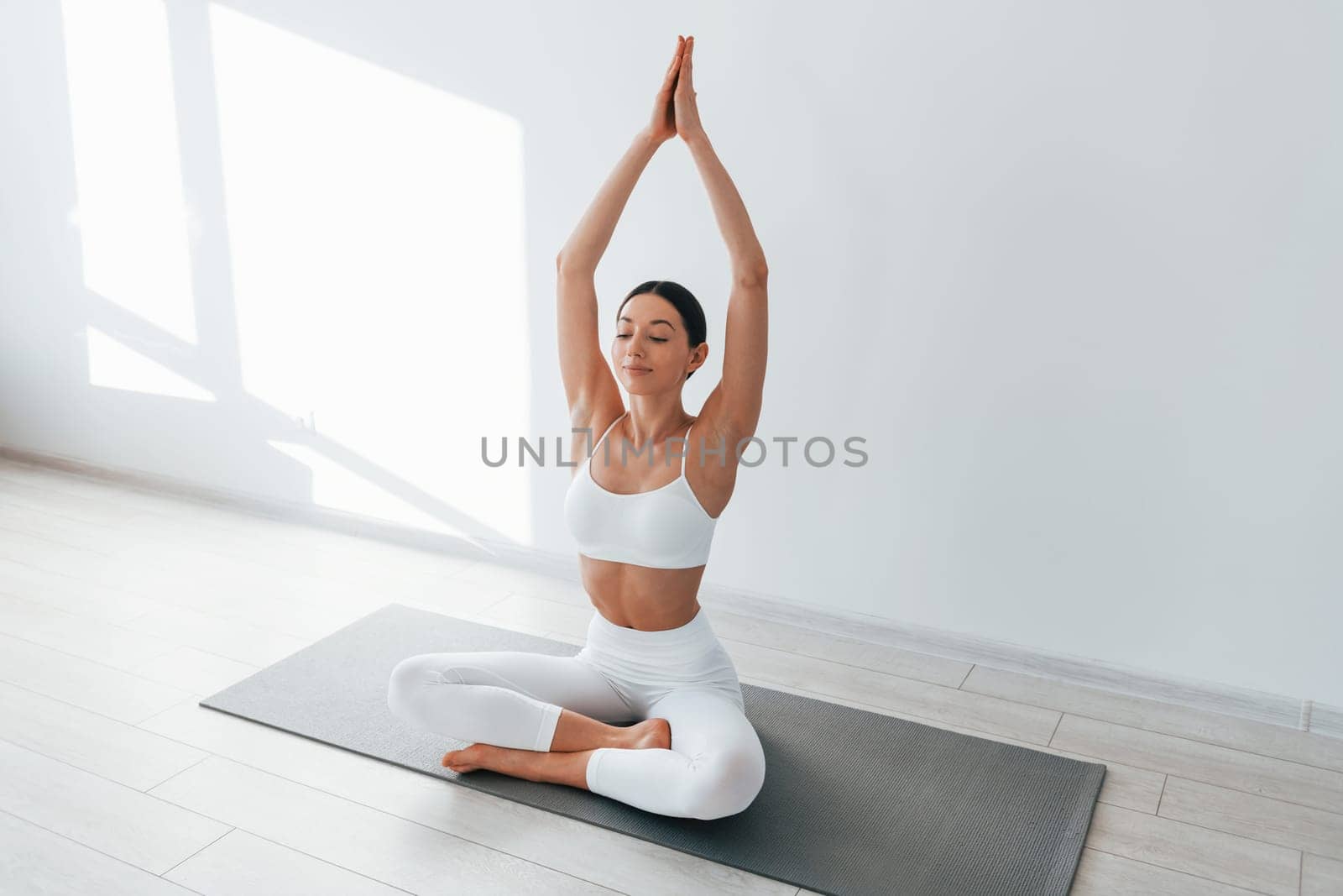 Young caucasian woman with slim body shape is indoors at daytime by Standret