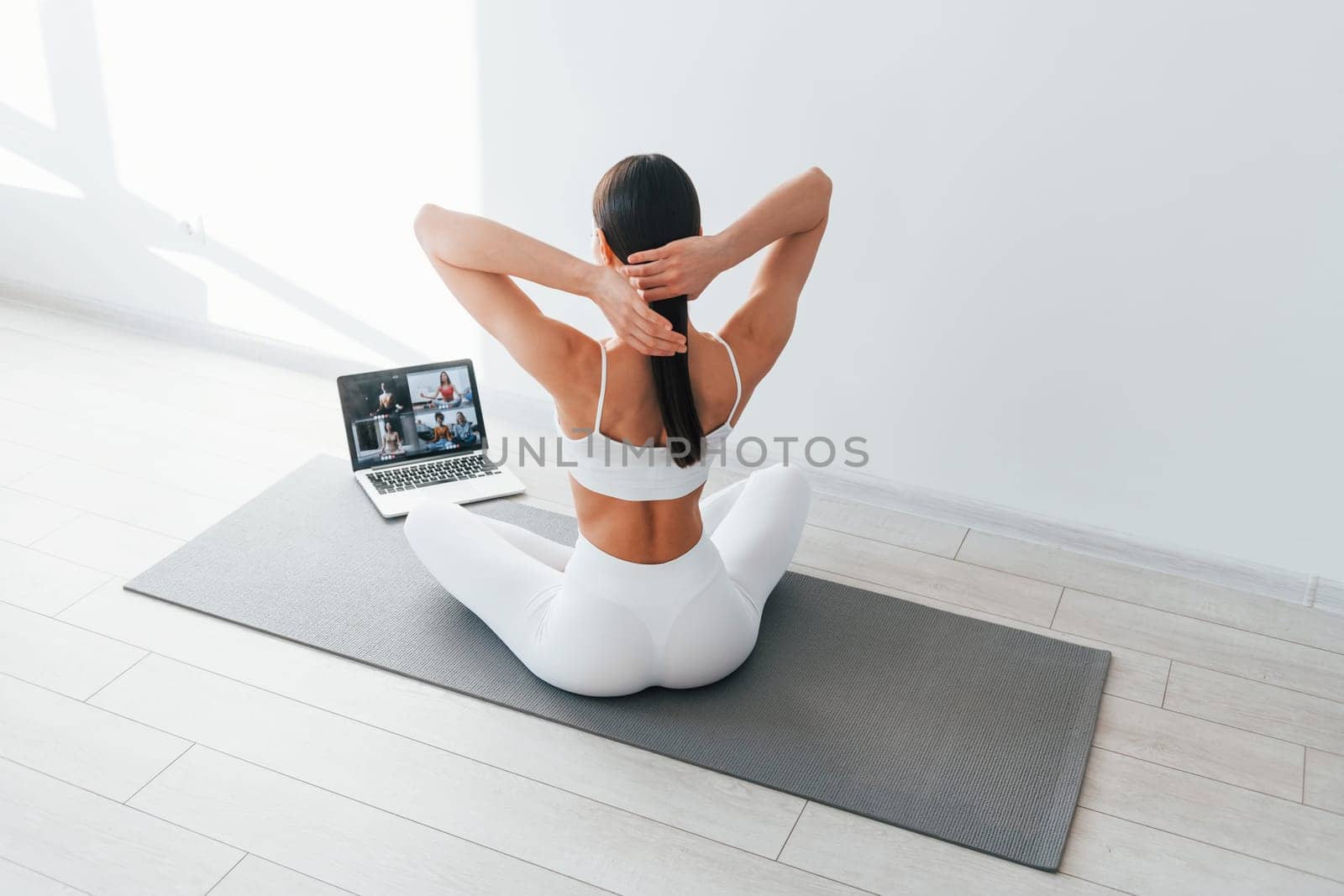 With laptop. Young caucasian woman with slim body shape is indoors at daytime.