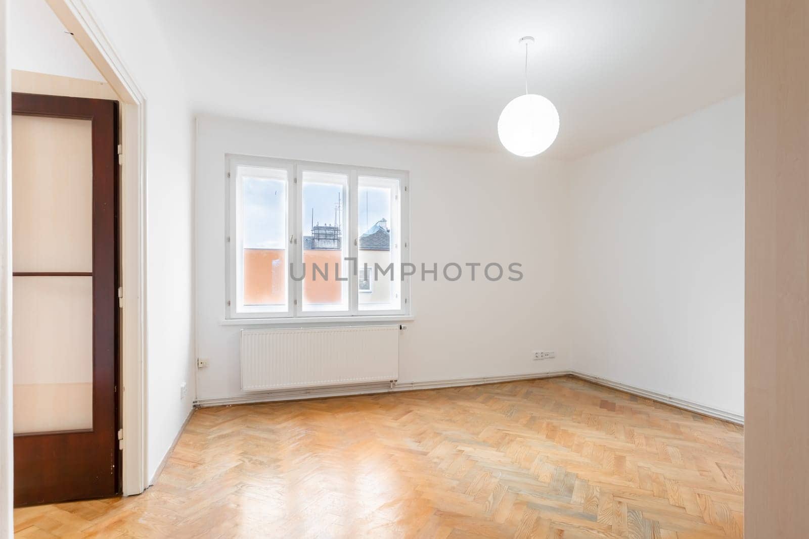 an empty room in an apartment with a wardrobe and a wooden parquet floor. High quality photo