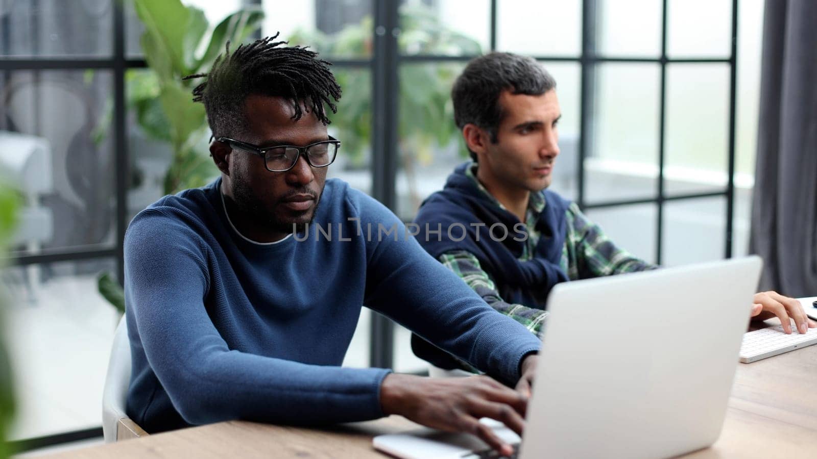 Two men colleagues sharing creative ideas, using digital tablet