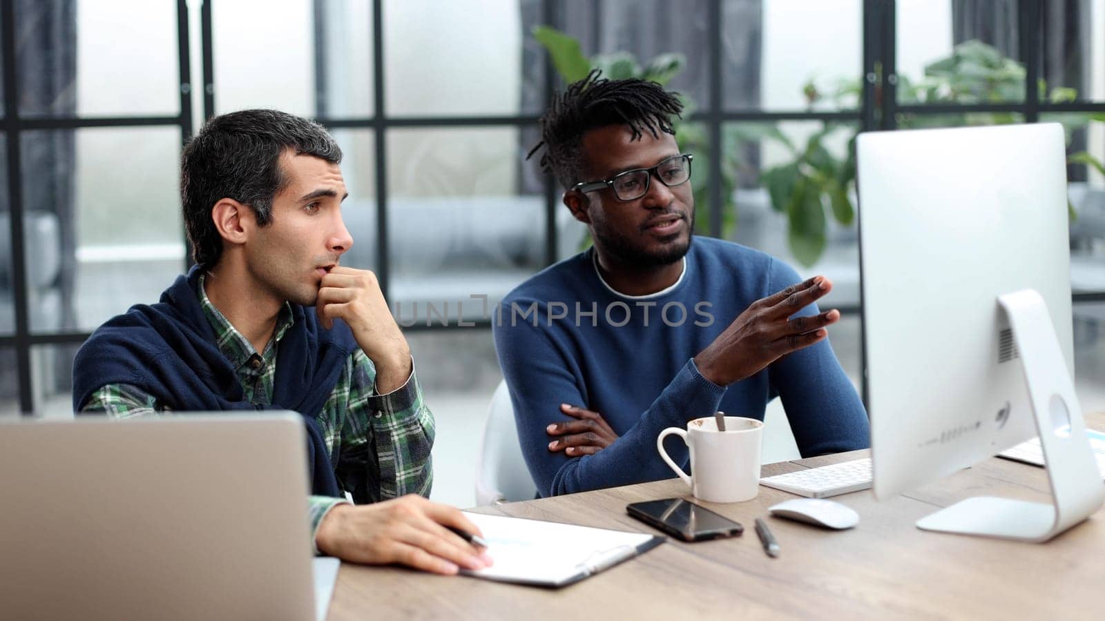 Business people working together in a modern trendy office behind a laptop. The concept of joint discussion of the project