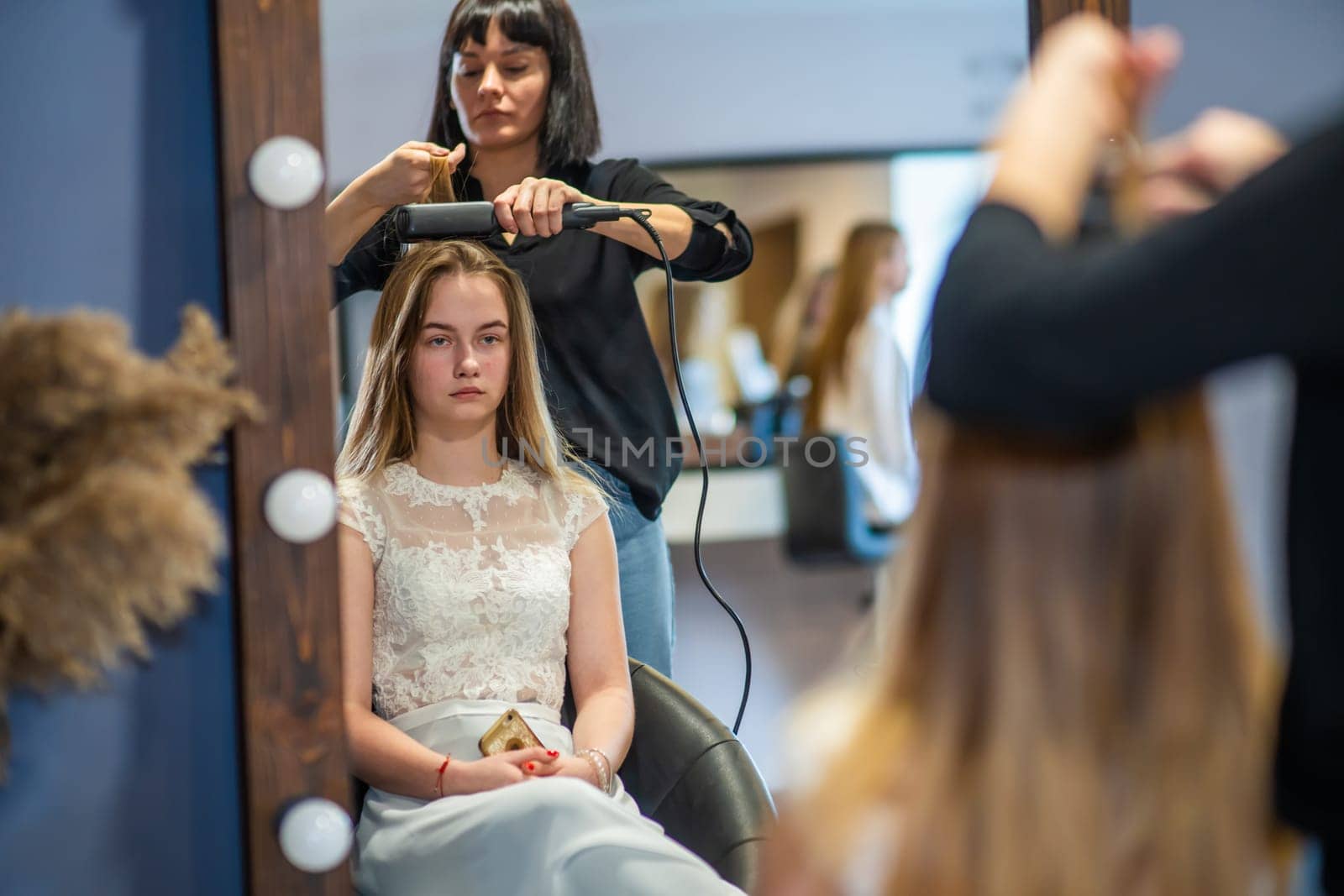 Girl hairdresser doing hairstyle in the form of spinning hair