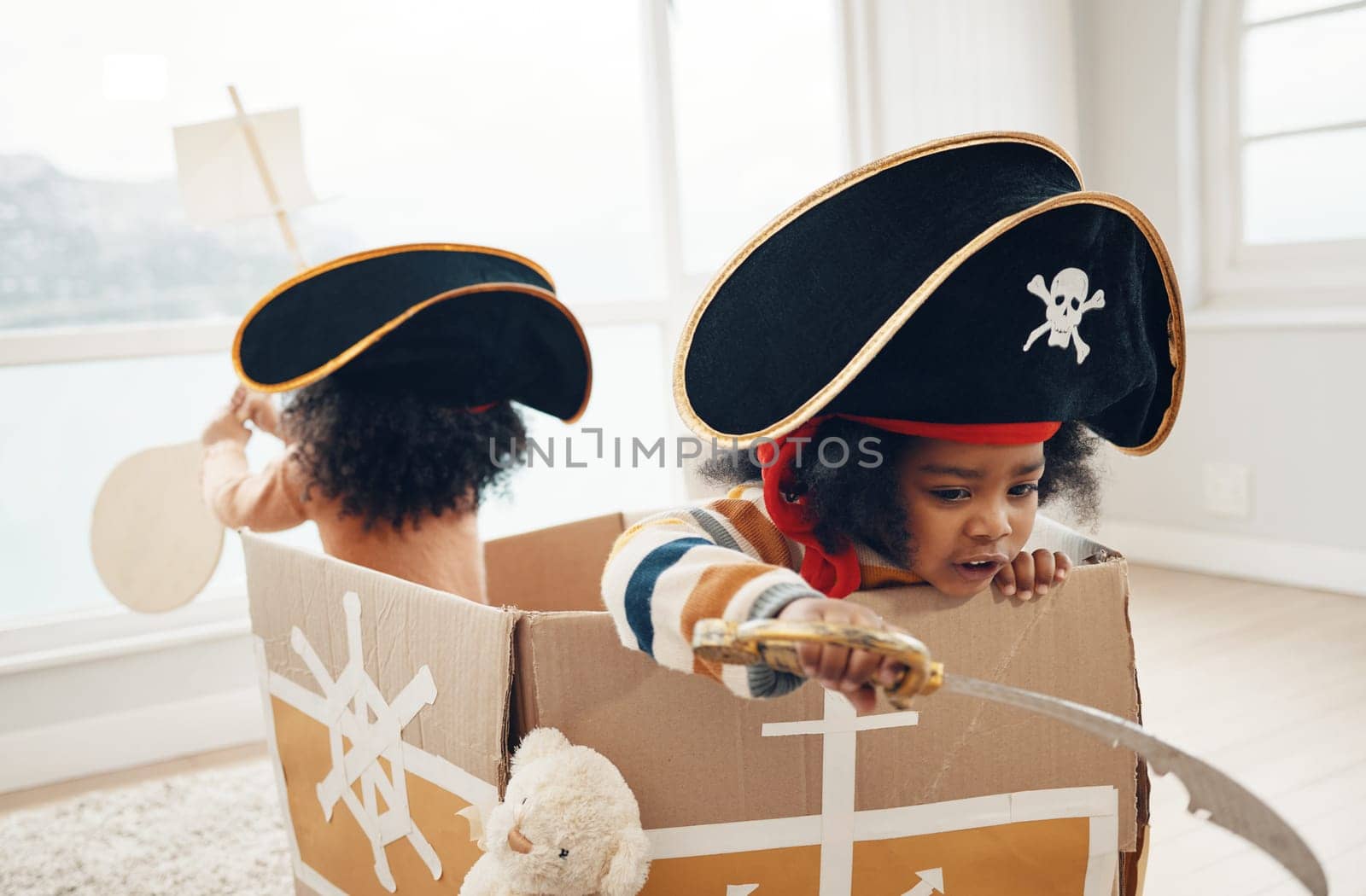 Playing, box ship and pirate children role play, fantasy imagine or pretend in cardboard container. Creative boat, fun home game or sailing black kids on Halloween cruise adventure with yacht captain.