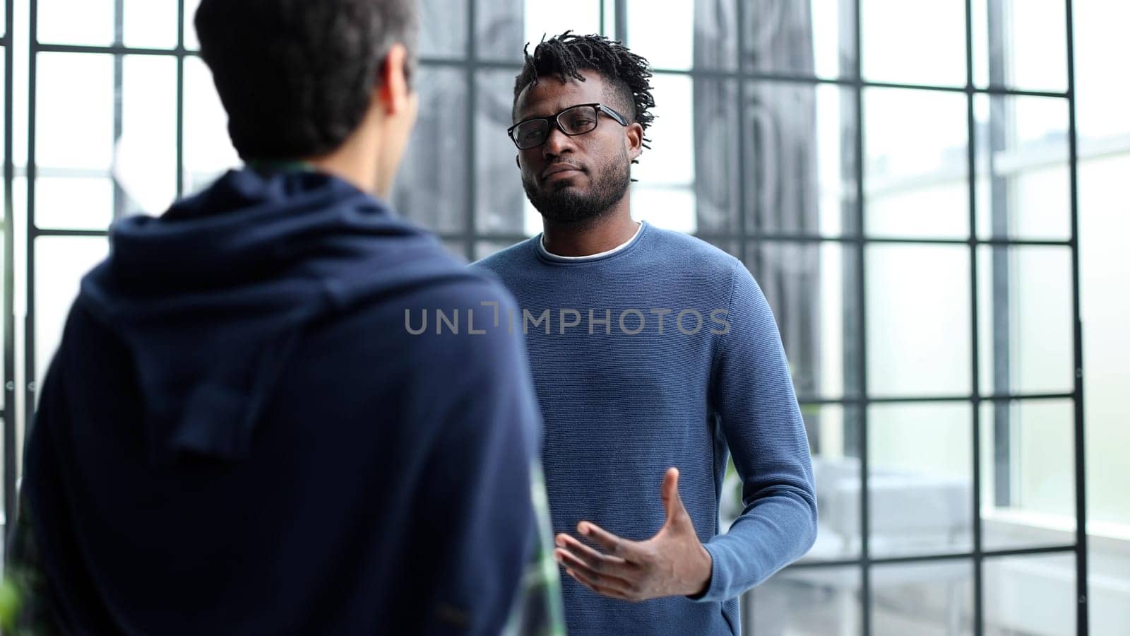 Business people talking near glass wall in office