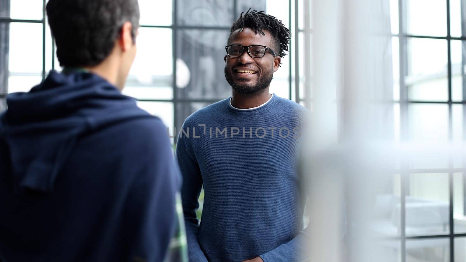 Business people talking near glass wall in office