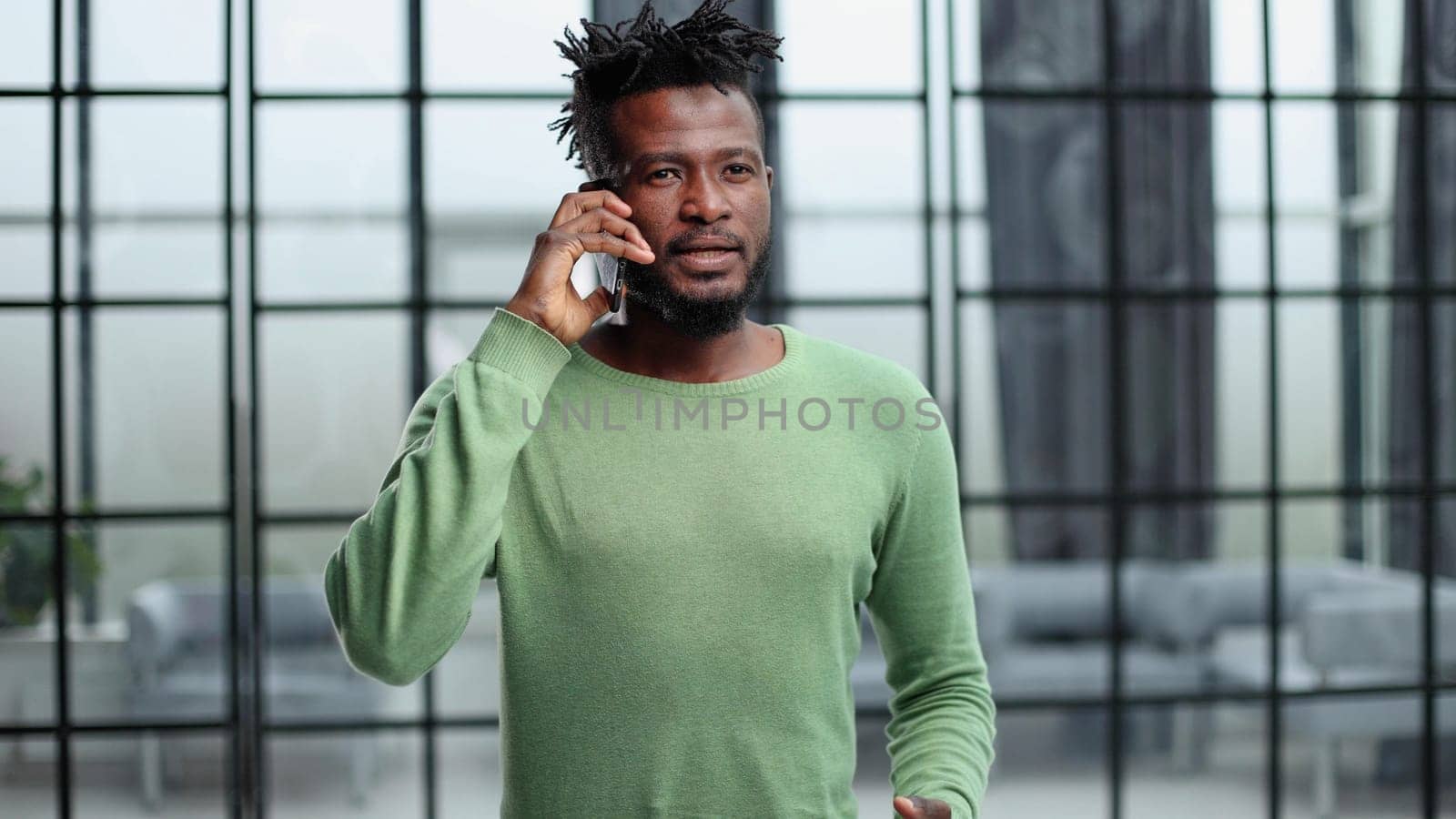 Businessman in office. Handsome man talking on phone at work.