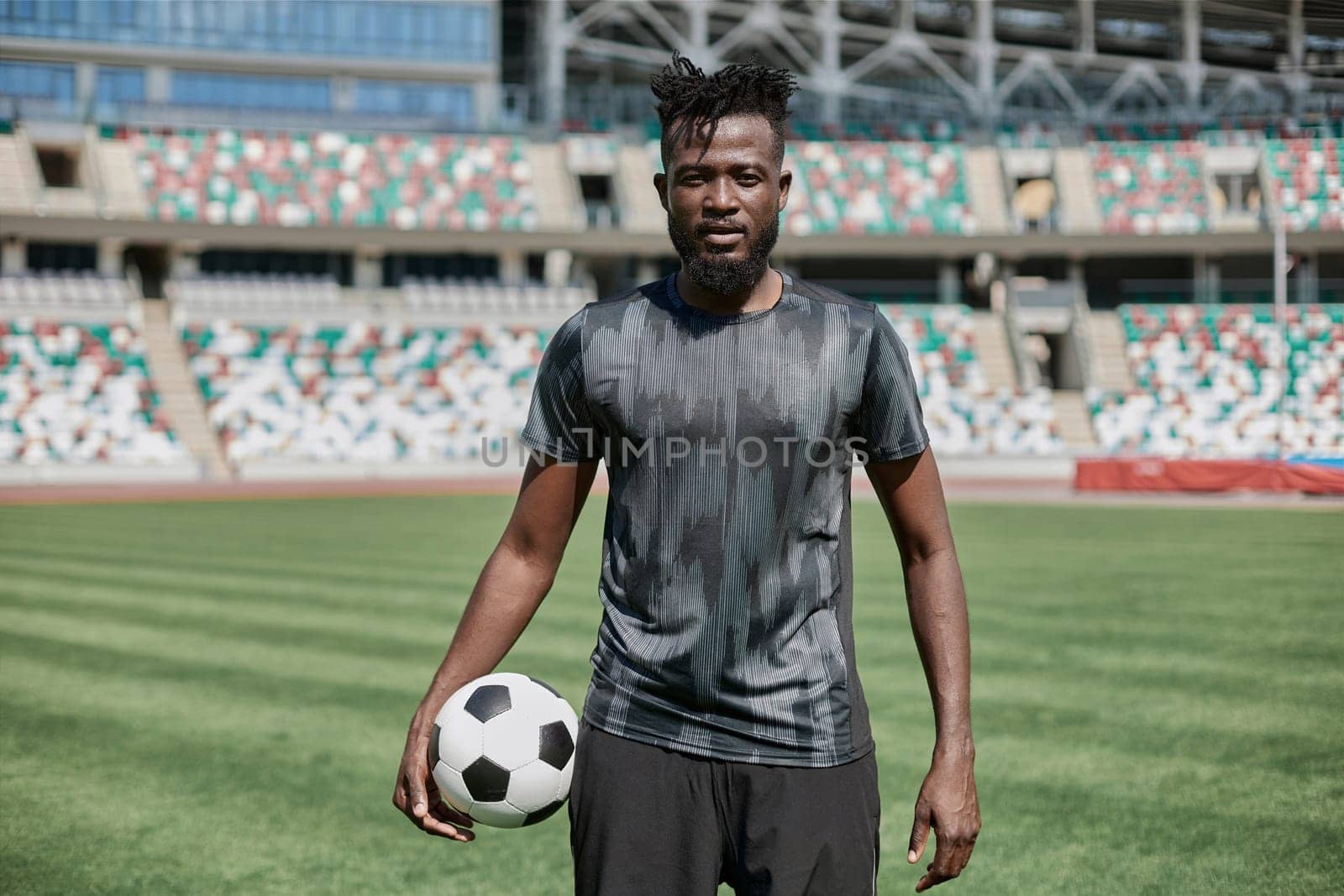 Intense portrait of a football player holding the ball in the stadium