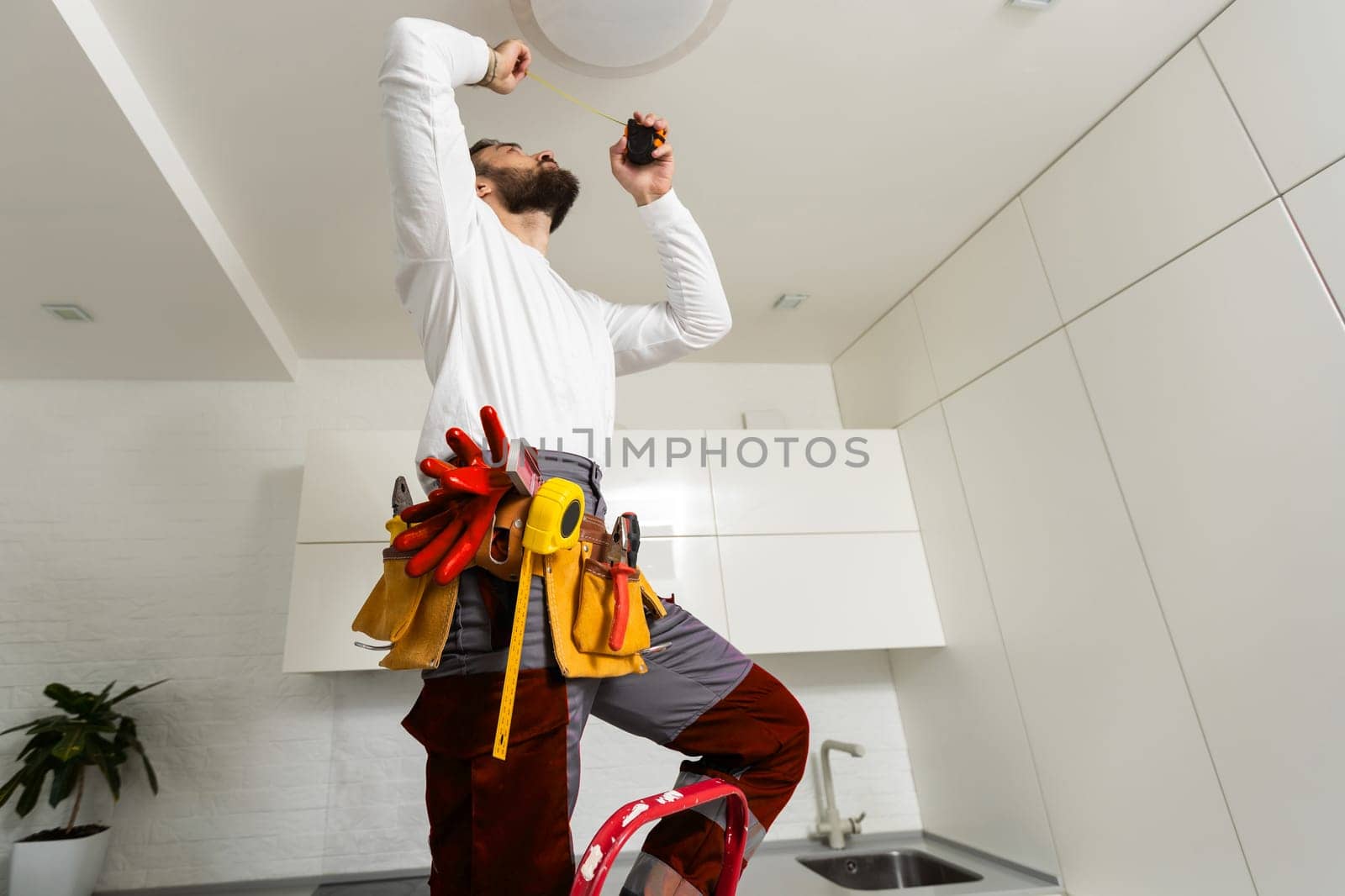 electrician installing led light bulbs in ceiling lamp.