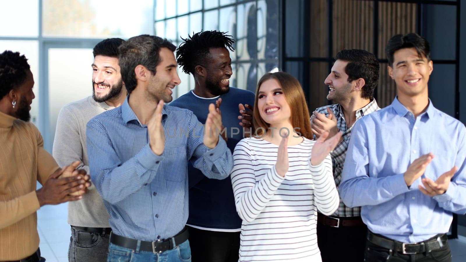 Happy satisfied multi-racial business people dressed in casual clothes cheering at camera after attending corporate seminar in office