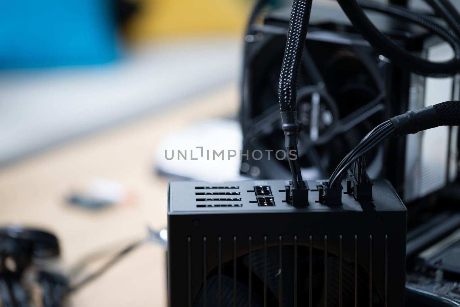Connecting new parts to a computer to increase its performance. A heat sink equipped with a fan. Computer parts standing on a table. Active cooling of the processor.