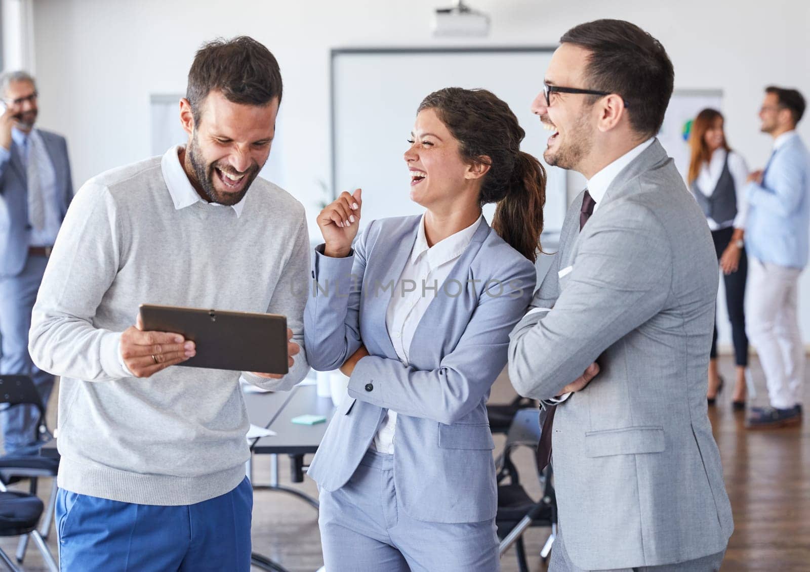A portrait of a young businesspeople holding a tablet and smiling during a meeting and presentation in the office. Business concept