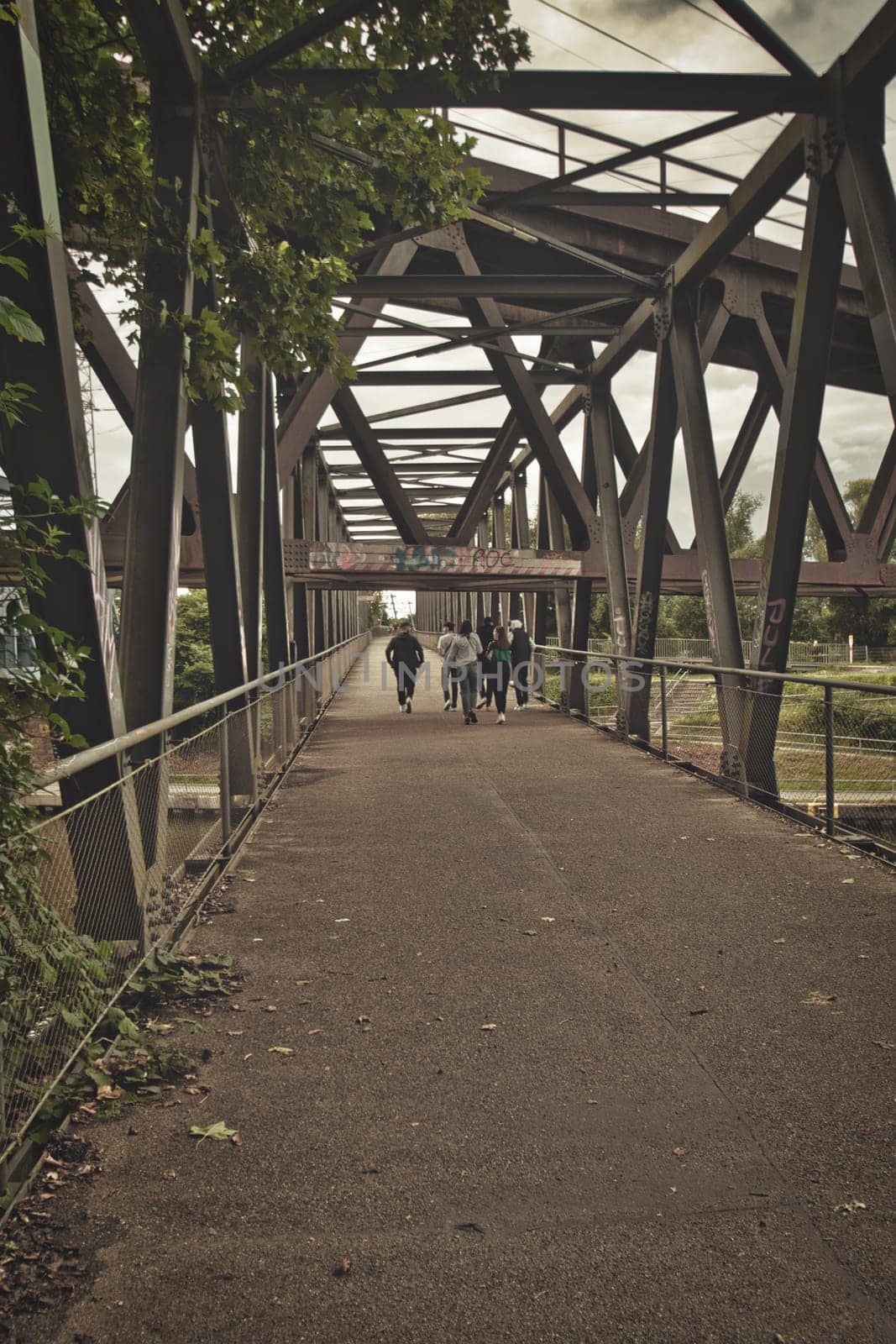 Group of teens walking down an old steel bridge in the Ruhr district of Germany