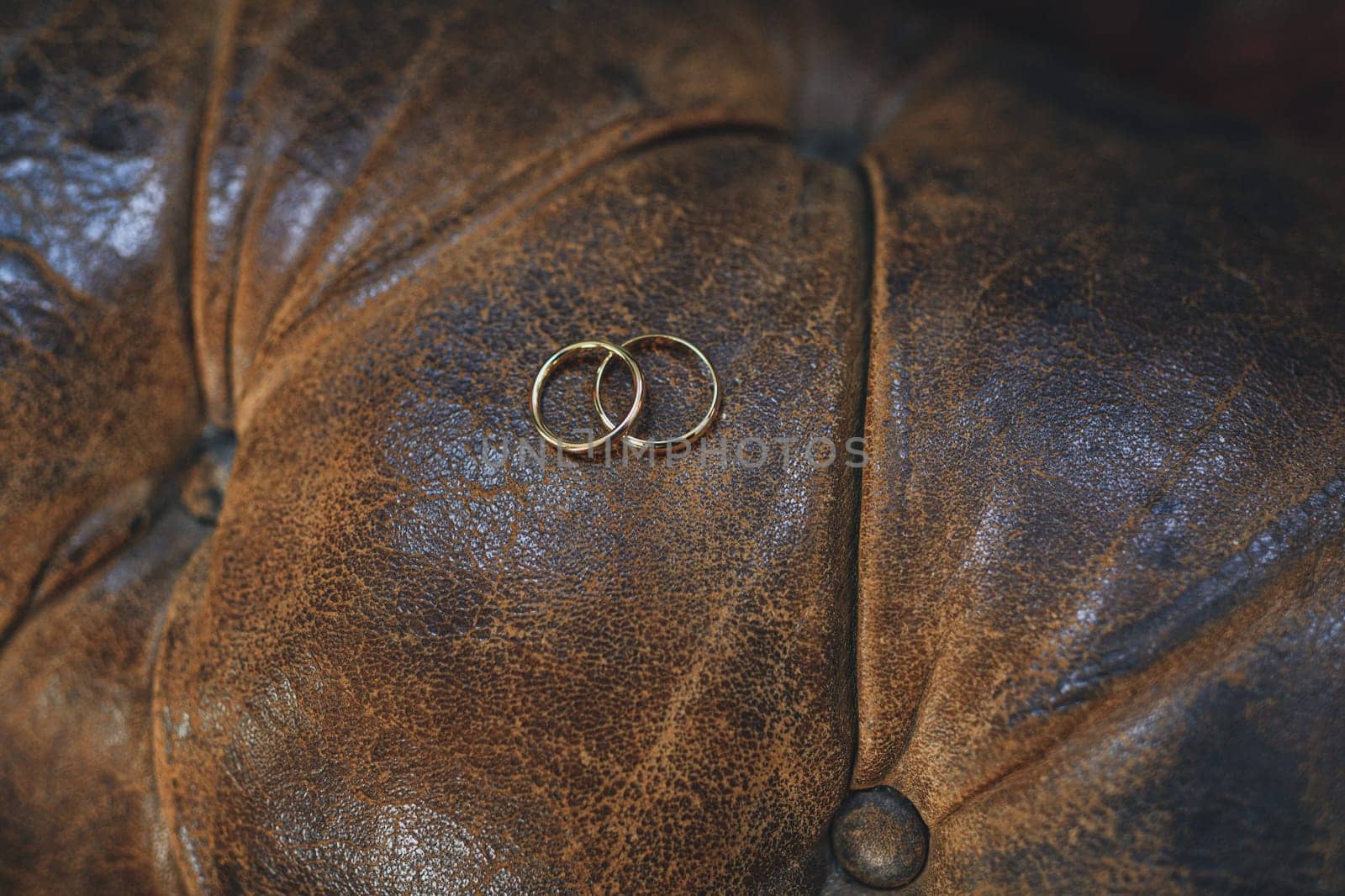 Two wedding rings on a leather chair