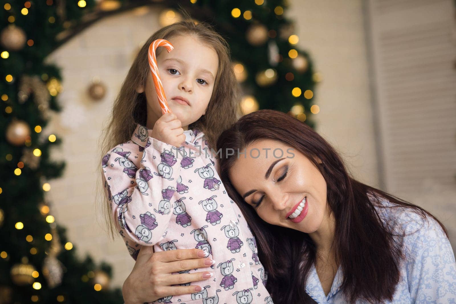 happy mother with her little child daughter playing near the Christmas tree