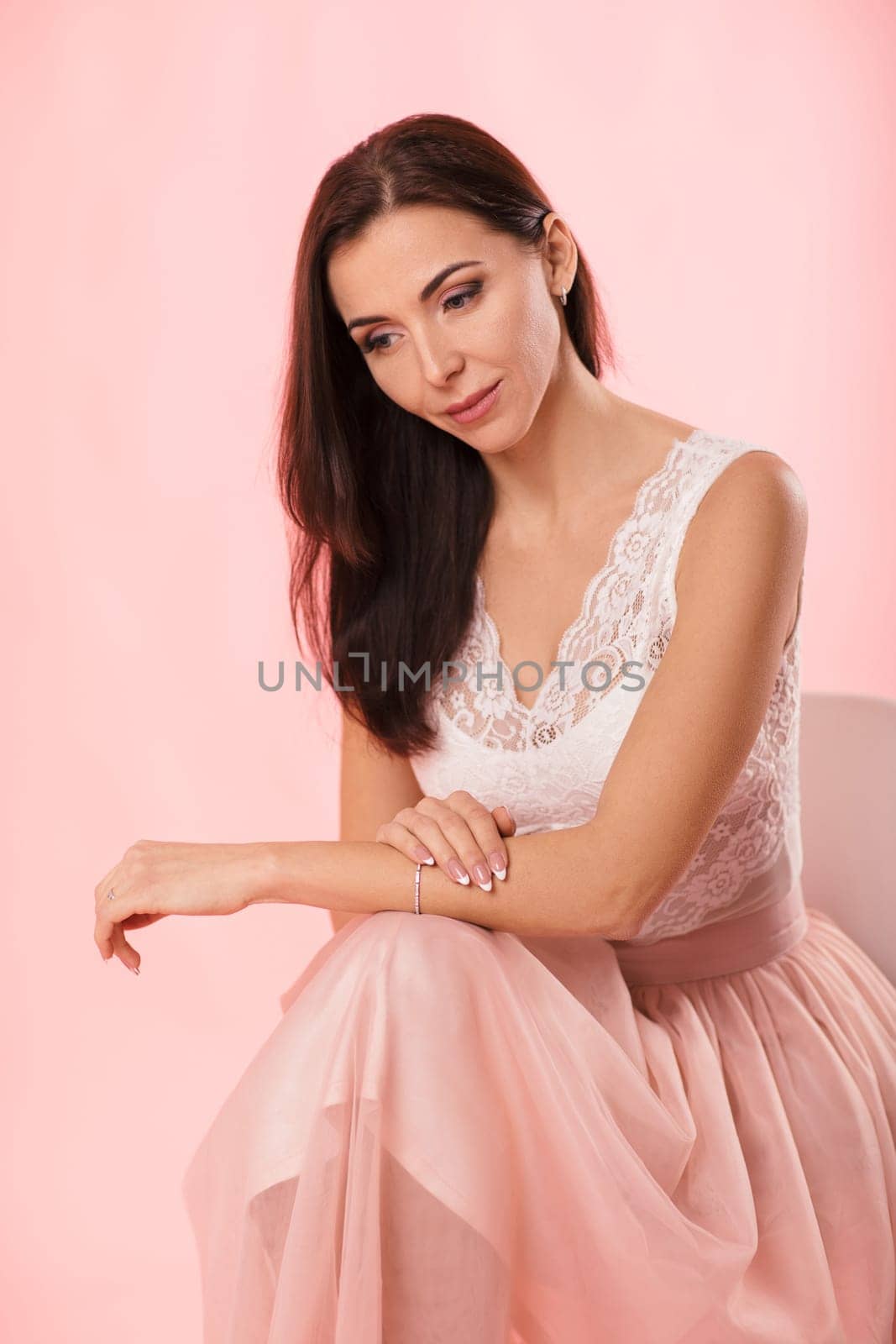 beautiful charming woman looking at camera on pink background. women's day.