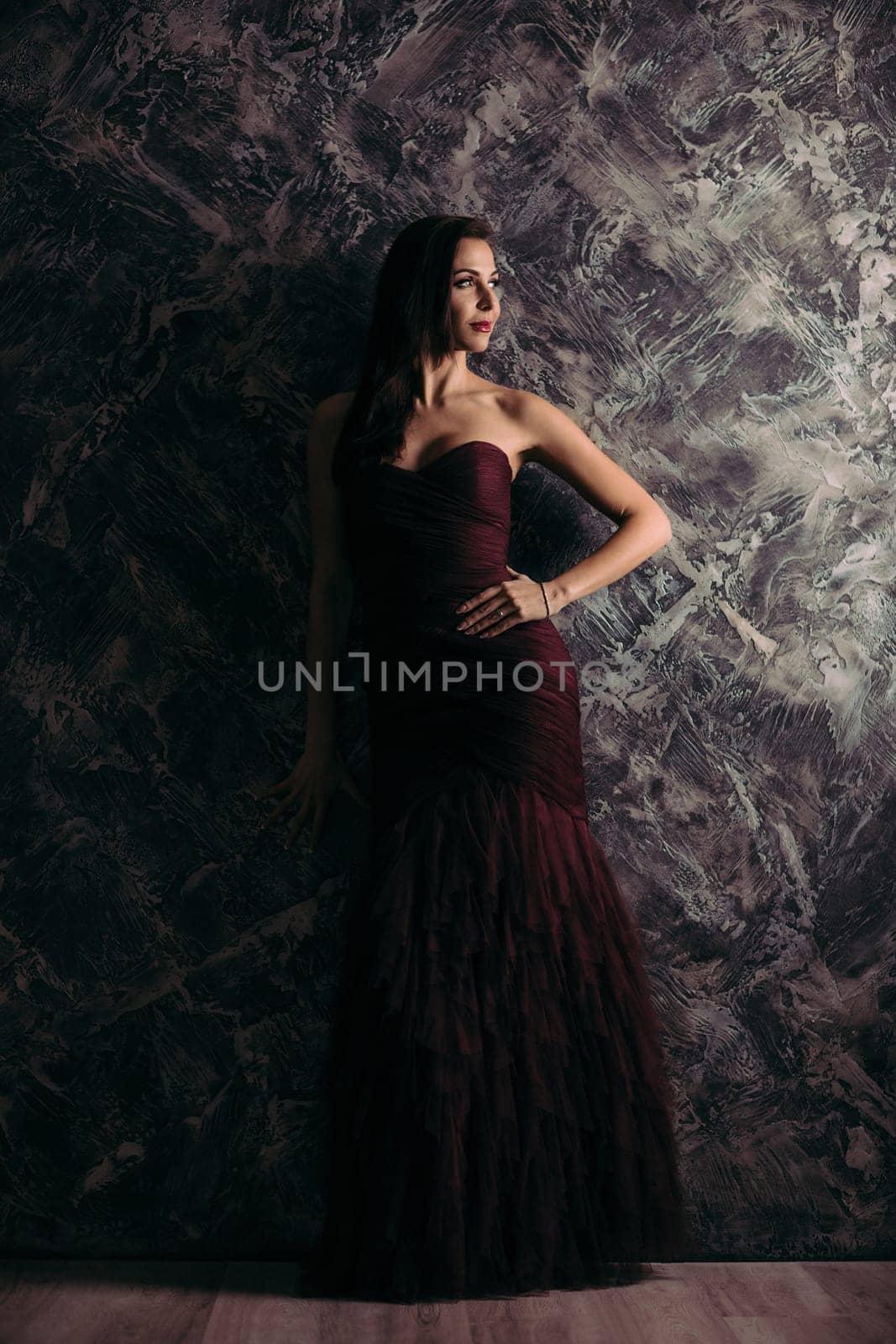 gorgeous sexy woman in evening dress posing over dark background