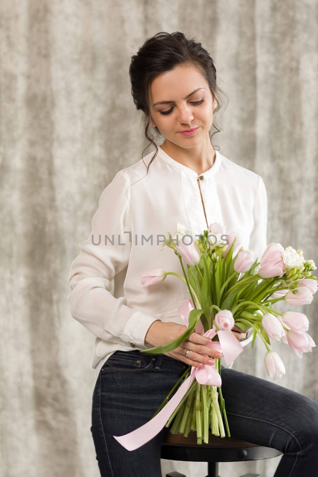 portrait of a beautiful brunette woman with a bouquet of tulips flowers