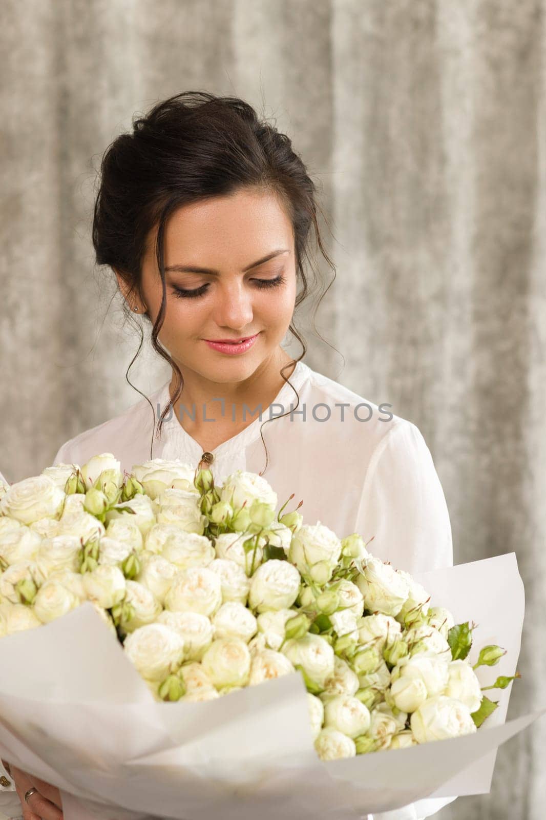 portrait of a beautiful brunette woman with a bouquet of tulips flowers