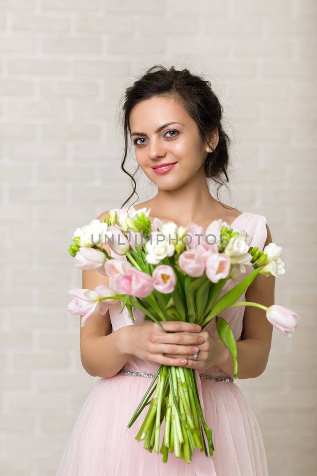 Portrait of beautiful bride with wedding bouquet of pink tulips