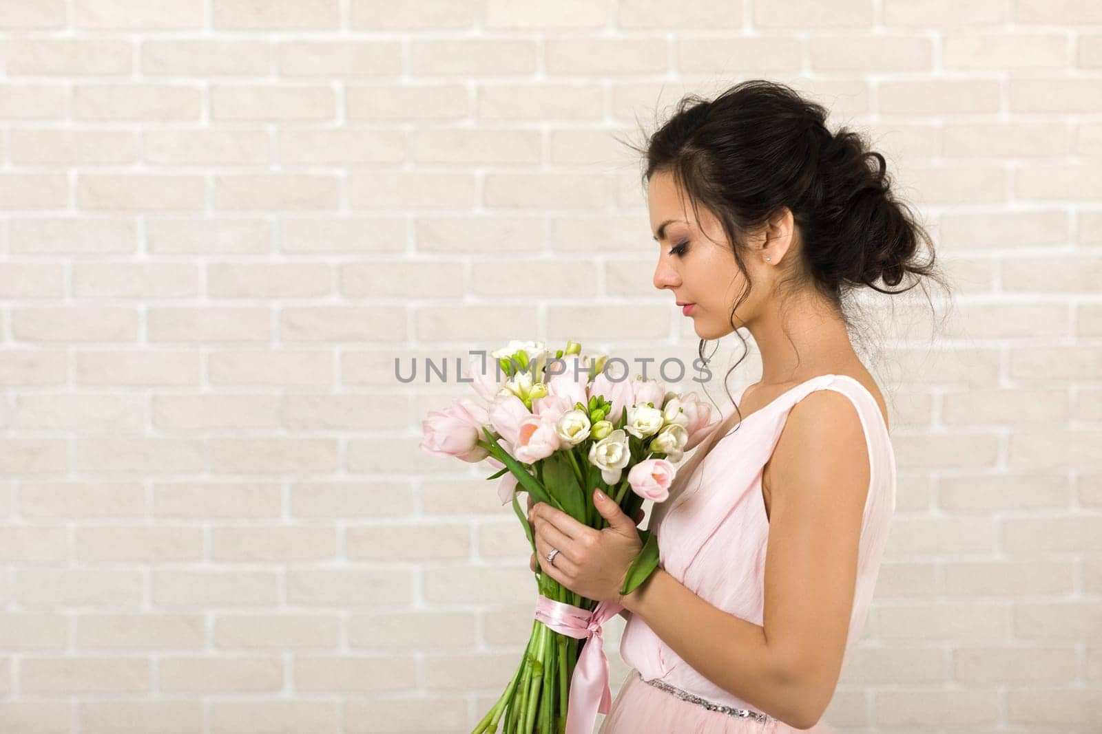 Portrait of beautiful bride with wedding bouquet of pink tulips