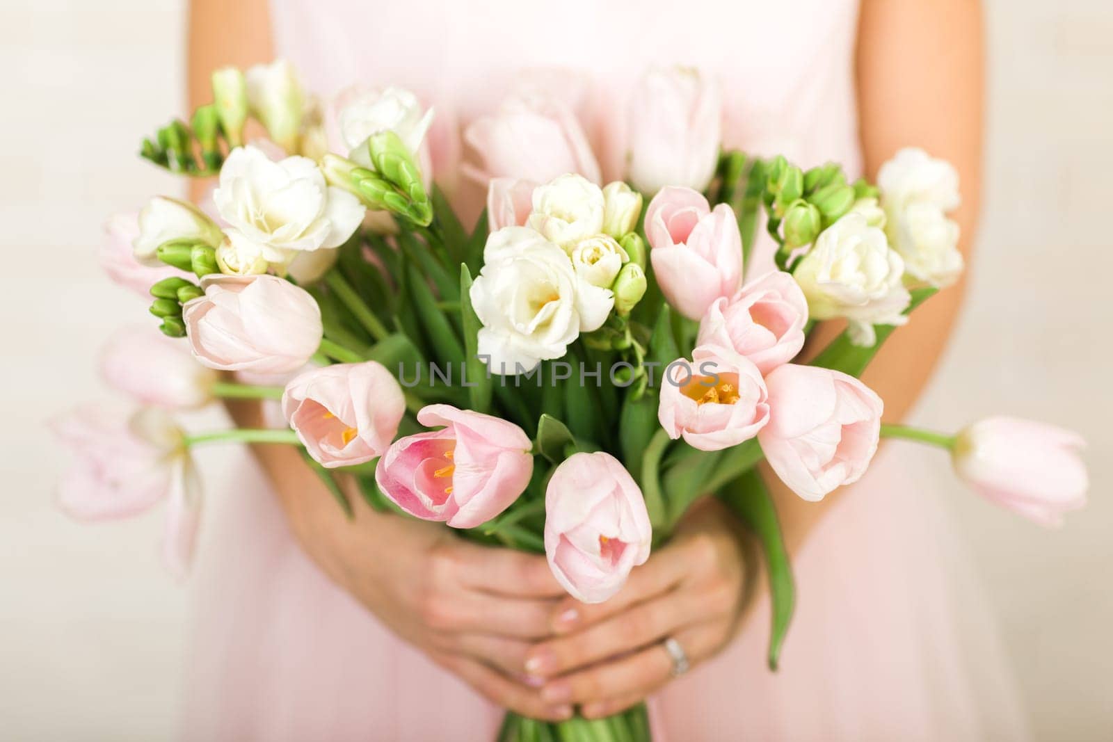 Wedding bouquet of pink tulips in bride's hands