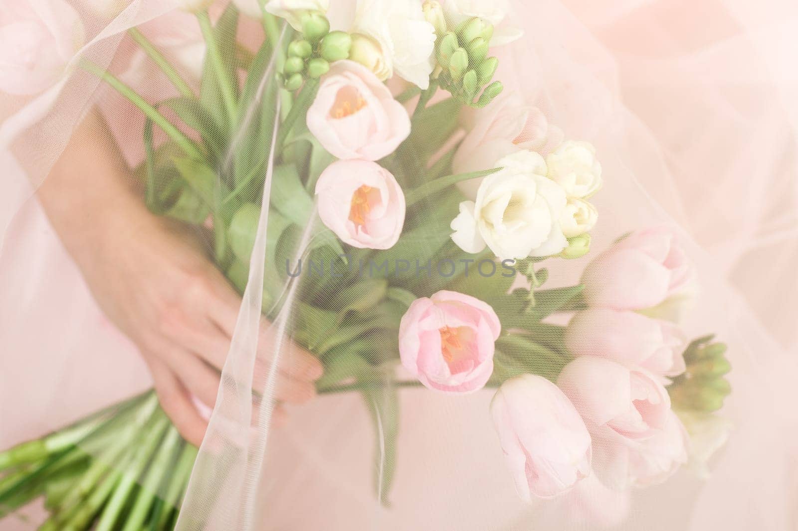 Wedding bouquet of pink tulips in bride's hands