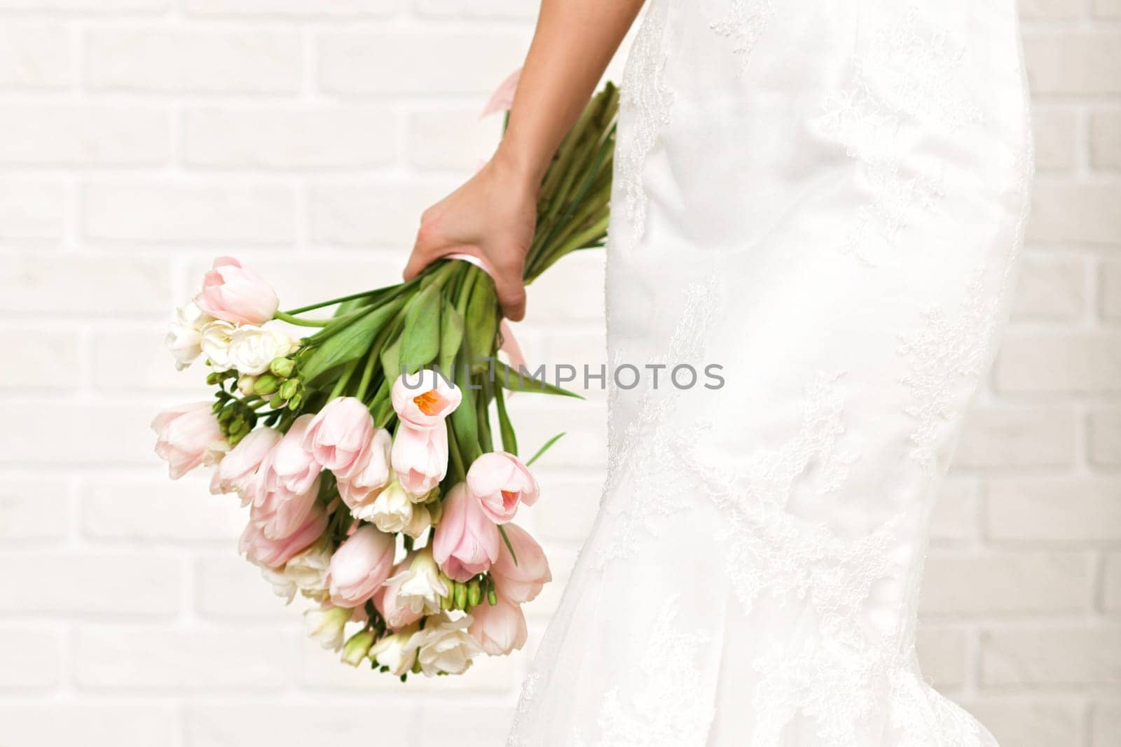 Wedding bouquet of pink tulips in bride's hands