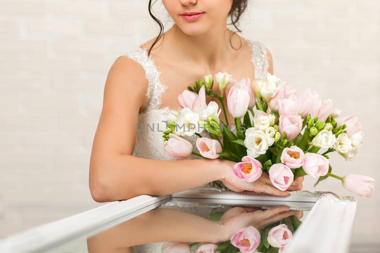 Portrait of beautiful bride with wedding bouquet of pink tulips