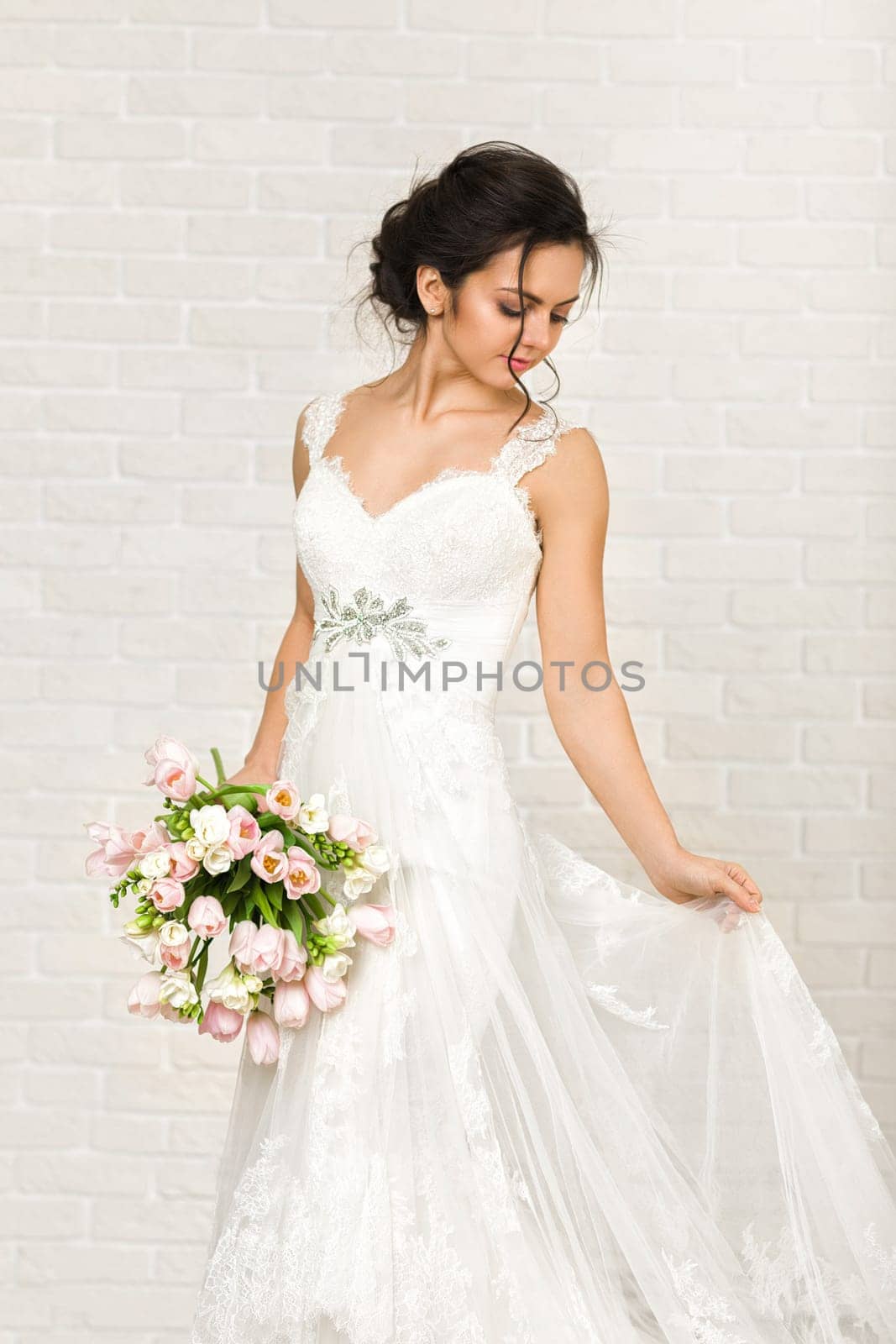 Portrait of beautiful bride with wedding bouquet of pink tulips