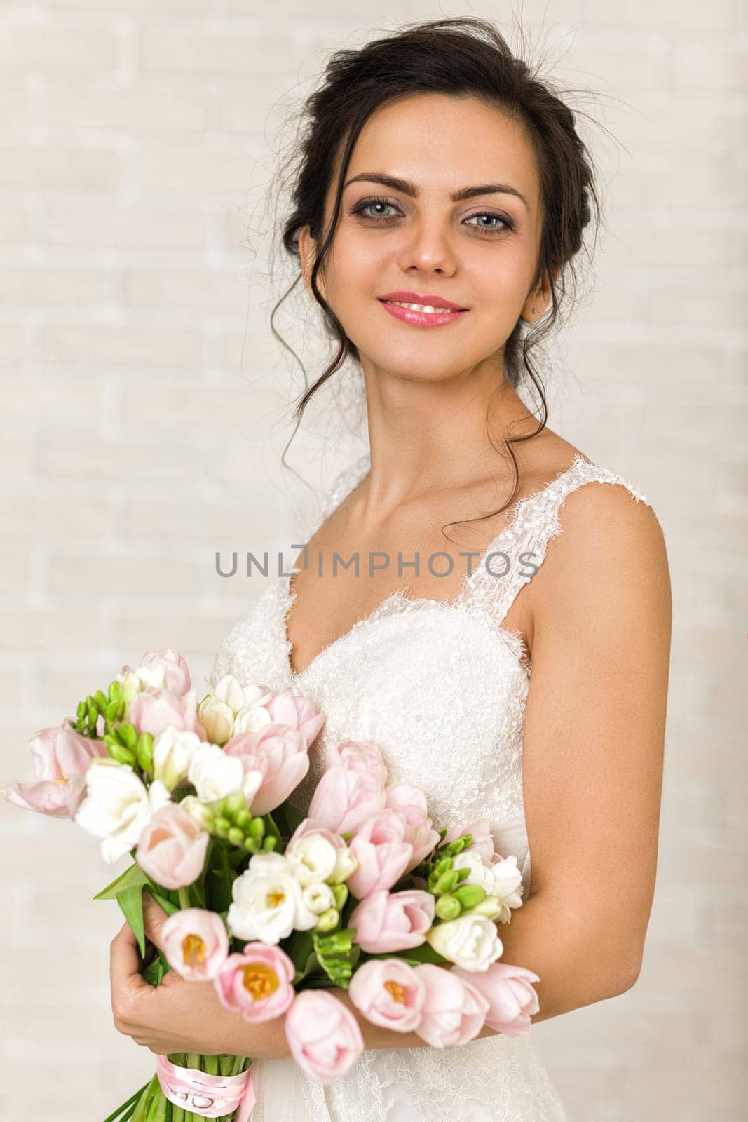 Portrait of beautiful bride with wedding bouquet of pink tulips