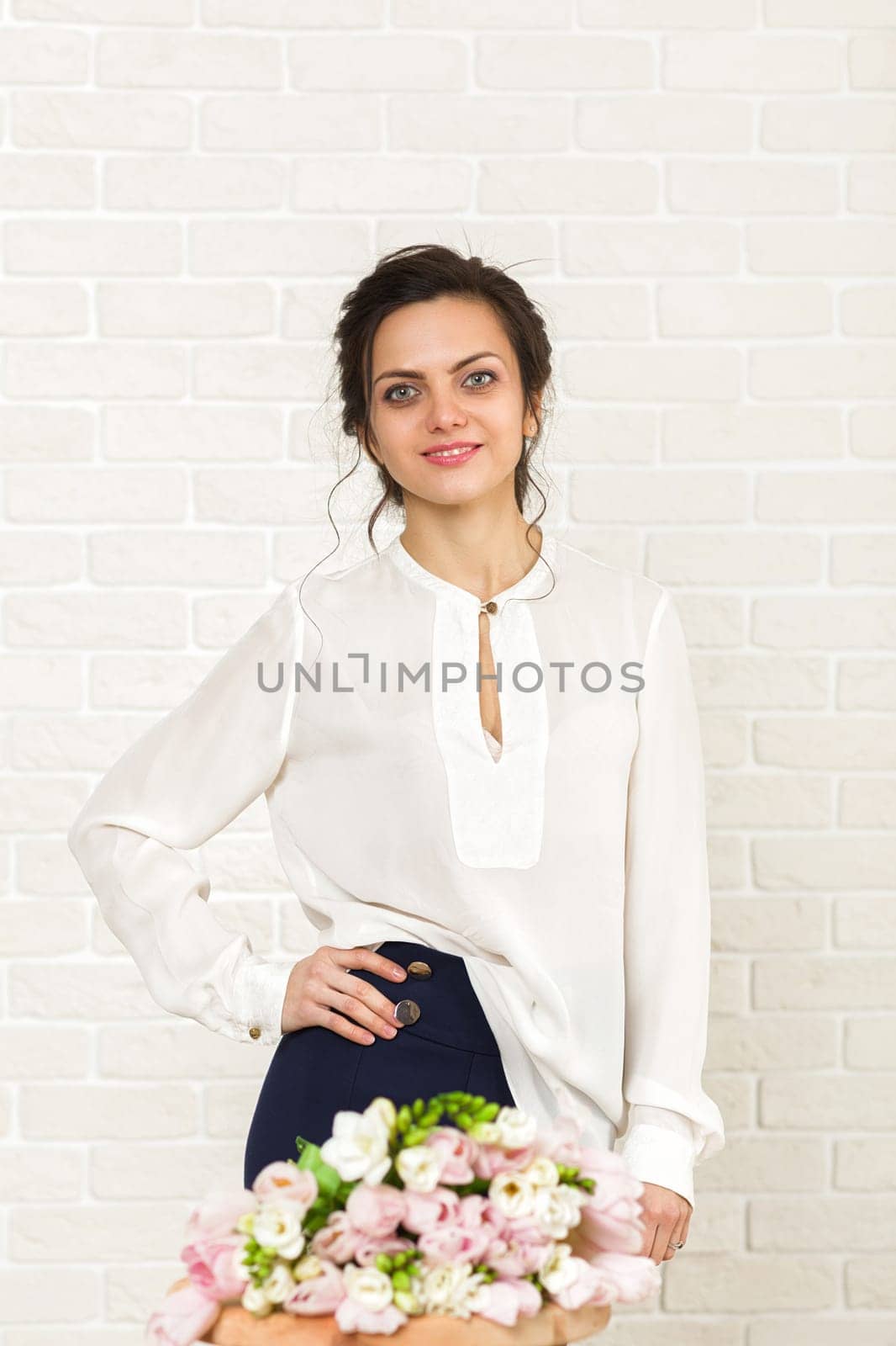 portrait of a beautiful brunette woman with a bouquet of tulips flowers