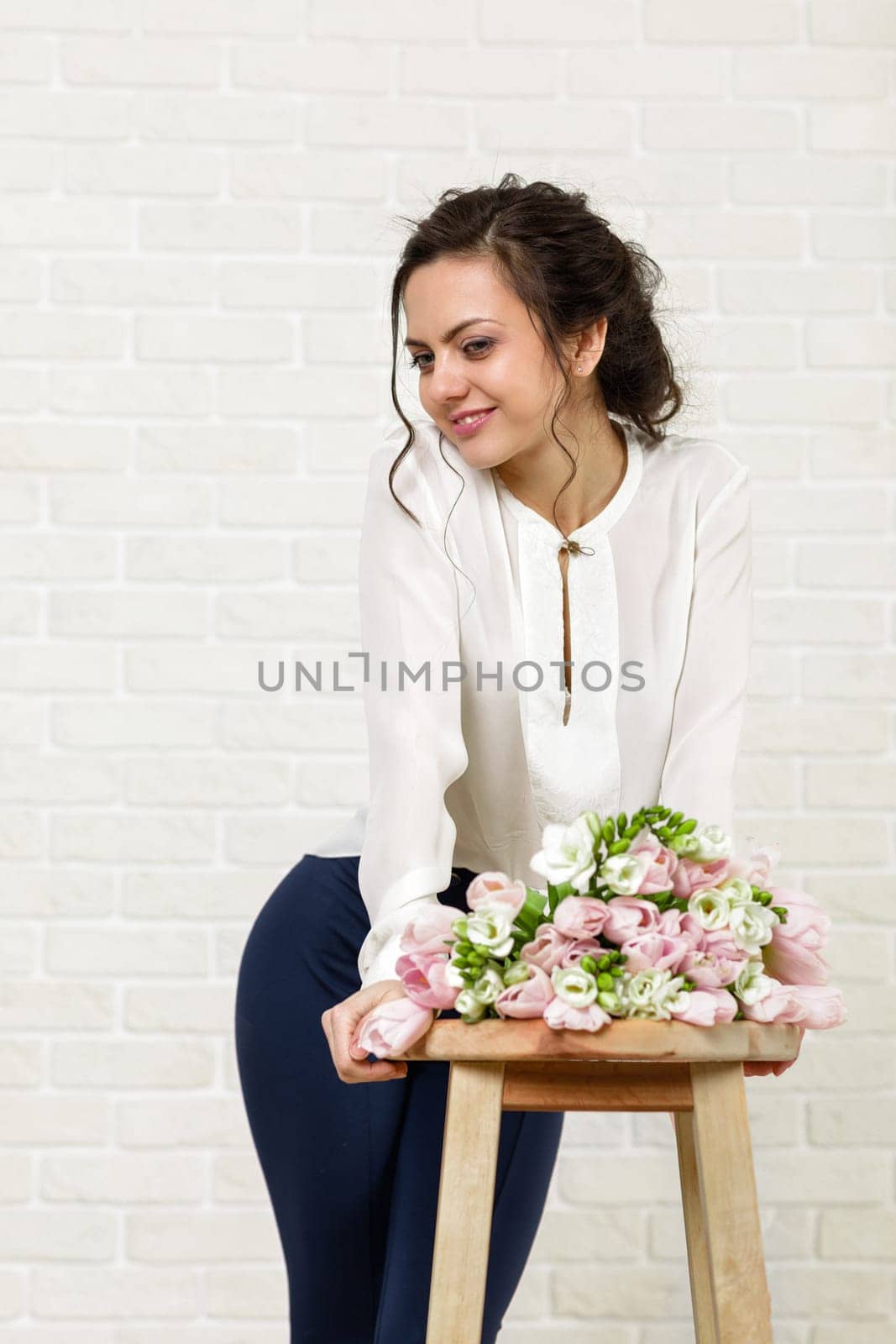 portrait of a beautiful brunette woman with a bouquet of tulips flowers
