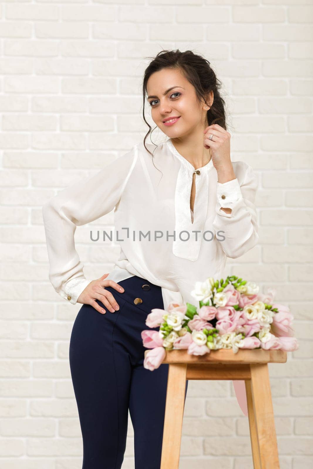 portrait of a beautiful brunette woman with a bouquet of tulips flowers