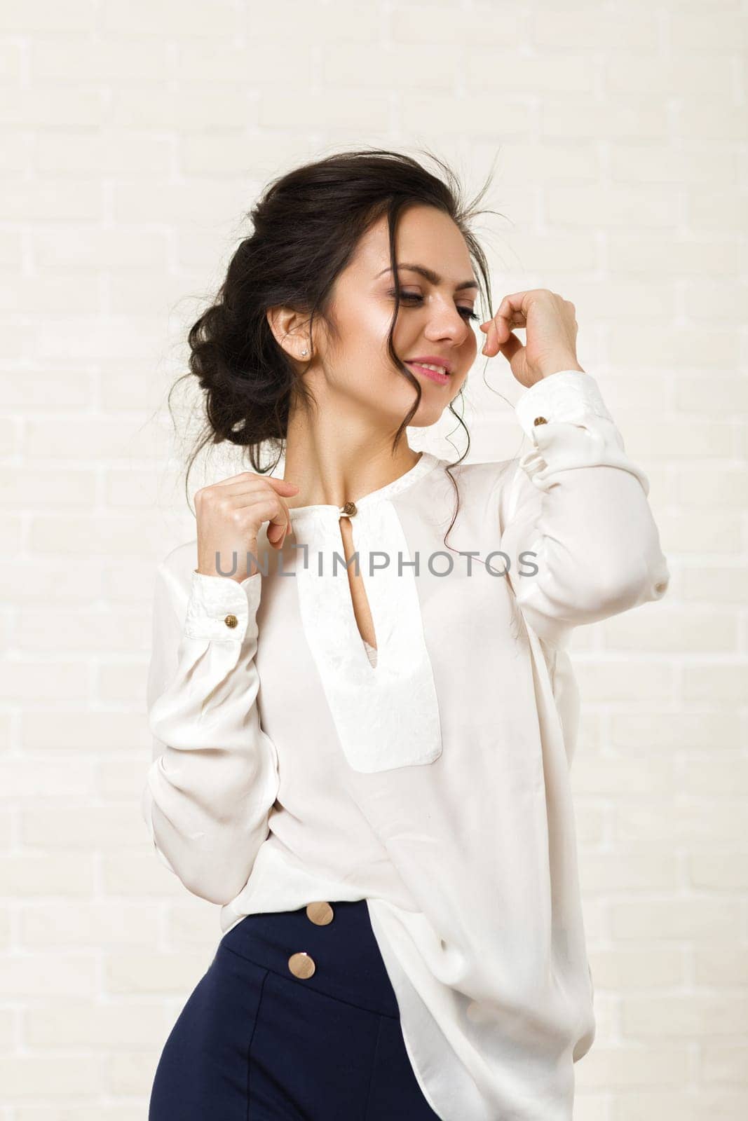 portrait of a beautiful happy brunette woman in a white blouse